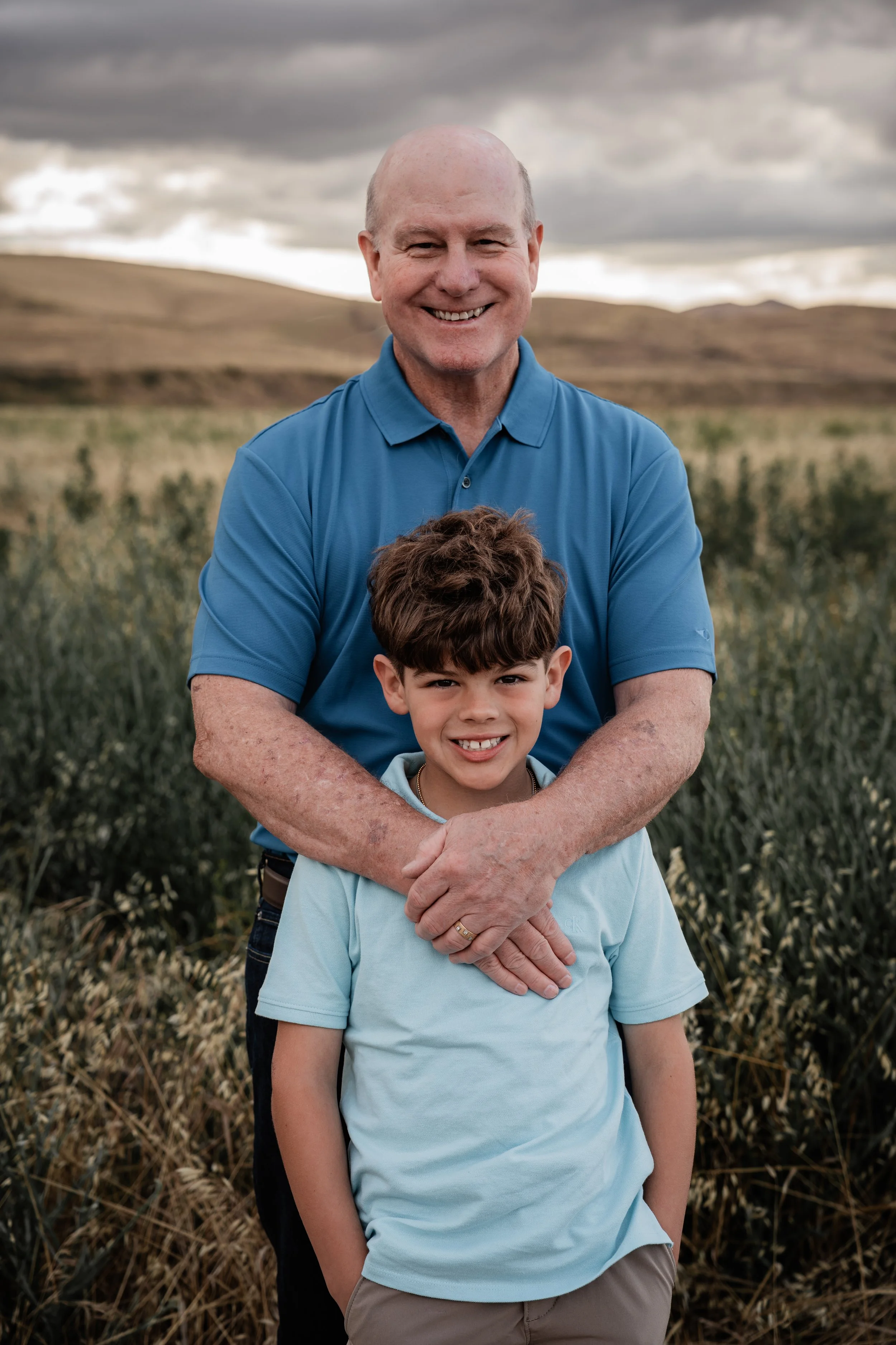 Grandfather and grandson standing in an open field. Photo taken by family photographer, Mikaela Tosta Photography in Patterson, CA.