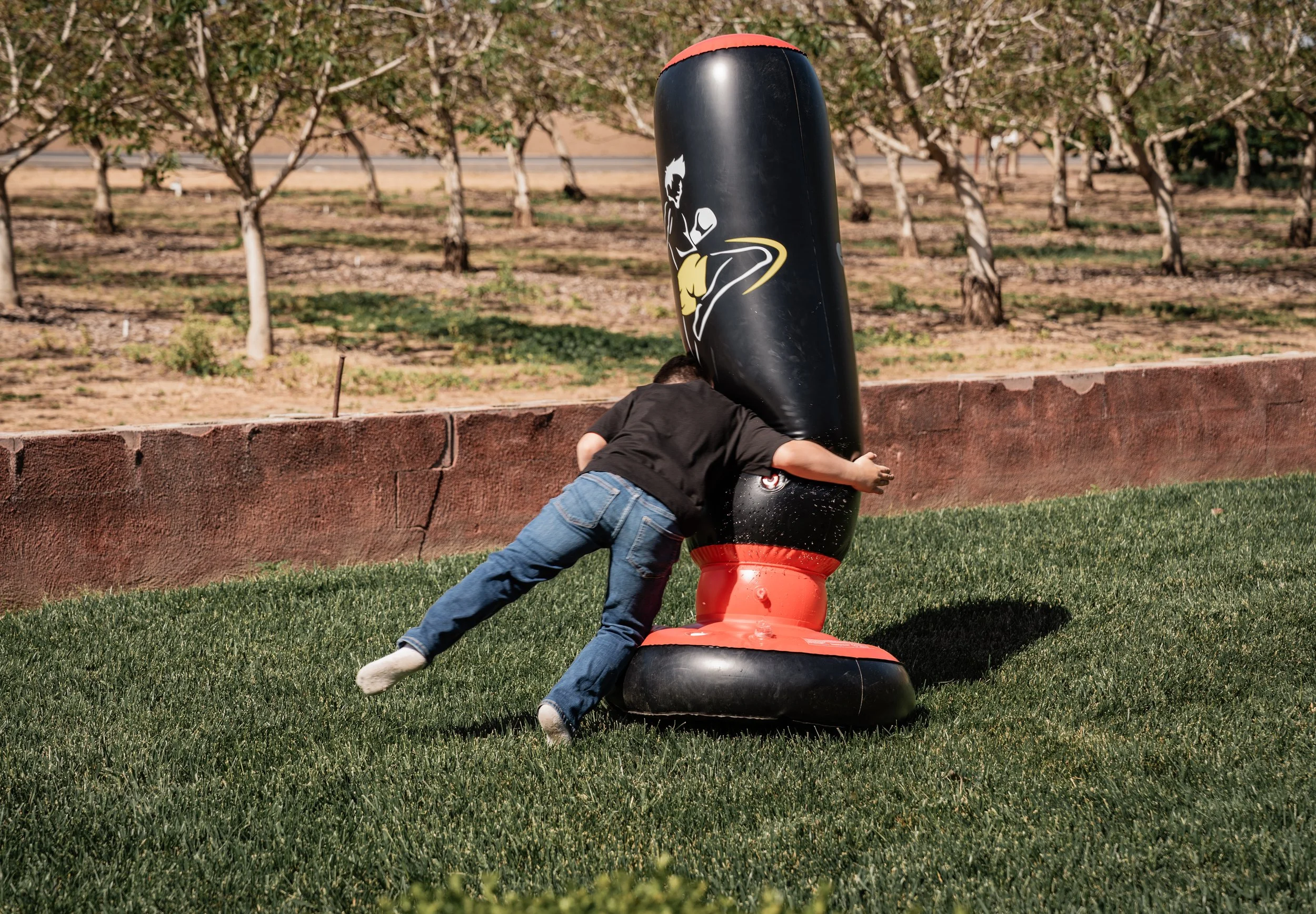 Boy tackling a tackle dummy. Photo taken in Patterson, CA by local family photographer Mikaela Tosta Photography.