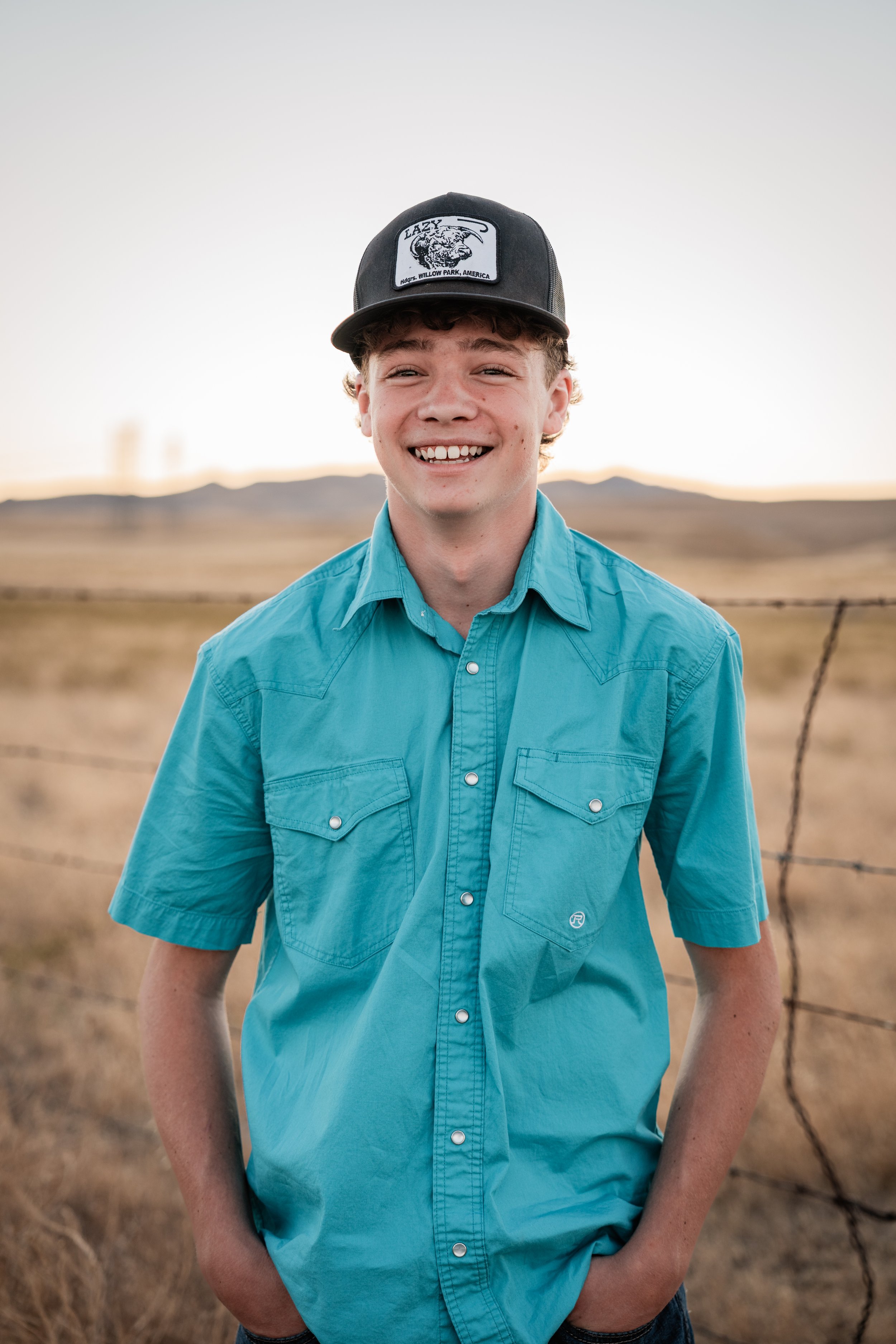 High school male senior posing for a portrait in the hills. Photo taken in Newman, CA by Mikaela Tosta Photography.
