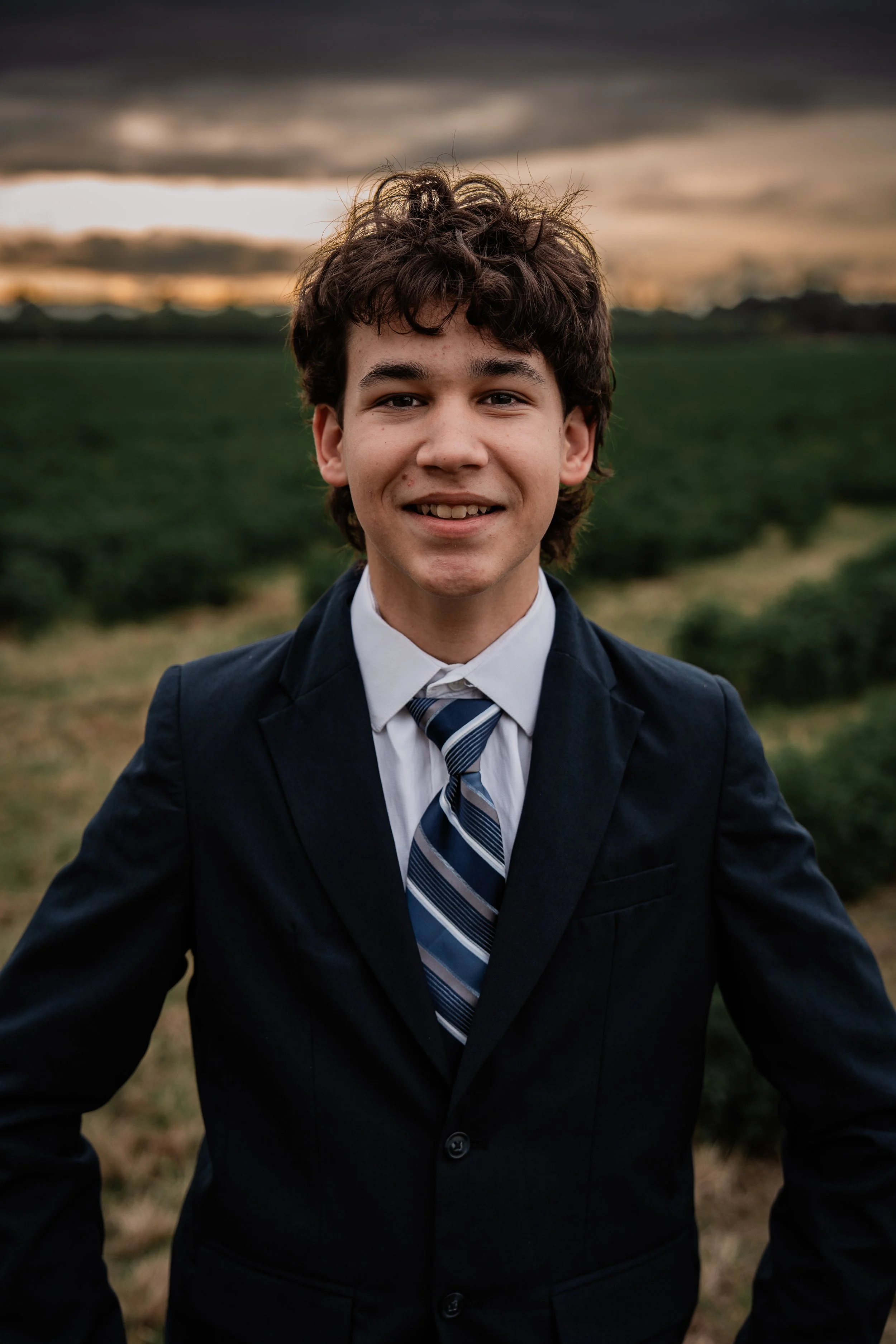 high school senior wearing a suit for a portrait. Photo taken in Crows Landing, CA by Mikaela Tosta Photography.