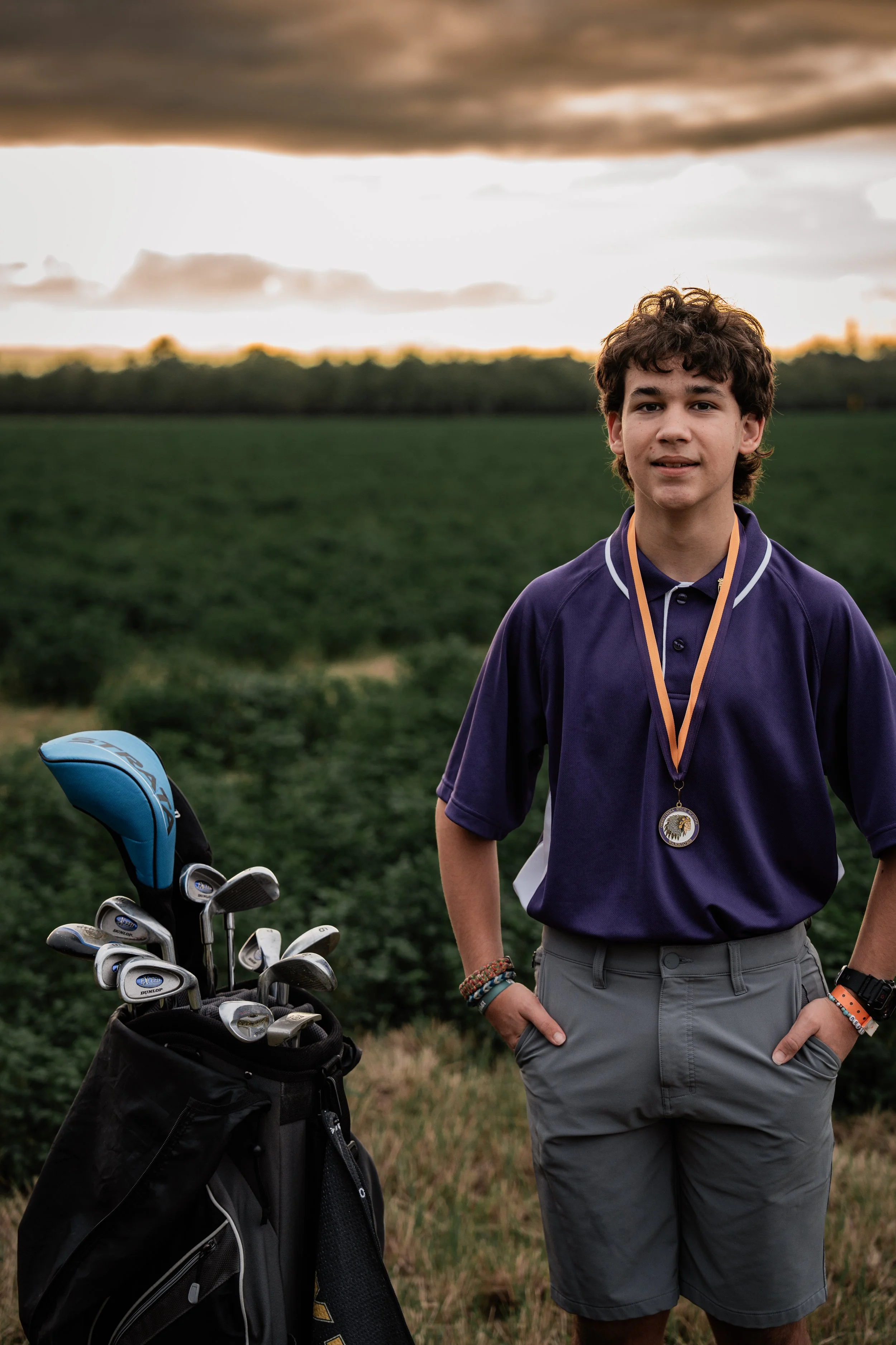 High school senior posing with his golf equipment. Photo taken in Crows Landing, CA by Mikaela Tosta Photography