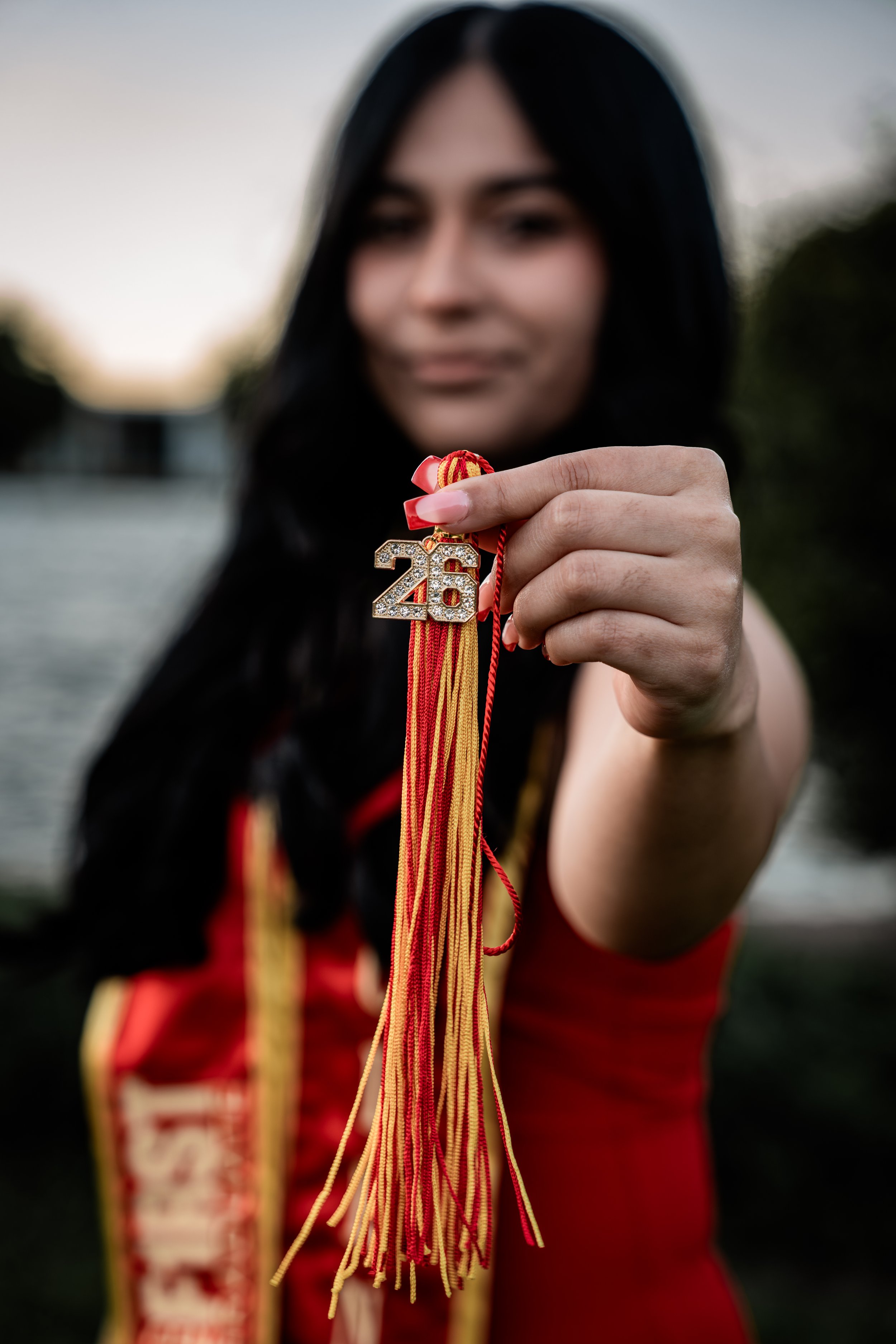 Photo of a Stanislaus State Graduate holding out their tassel. Photo taken in Turlock, CA by senior photographer and grad photographer Mikaela Tosta Photography.