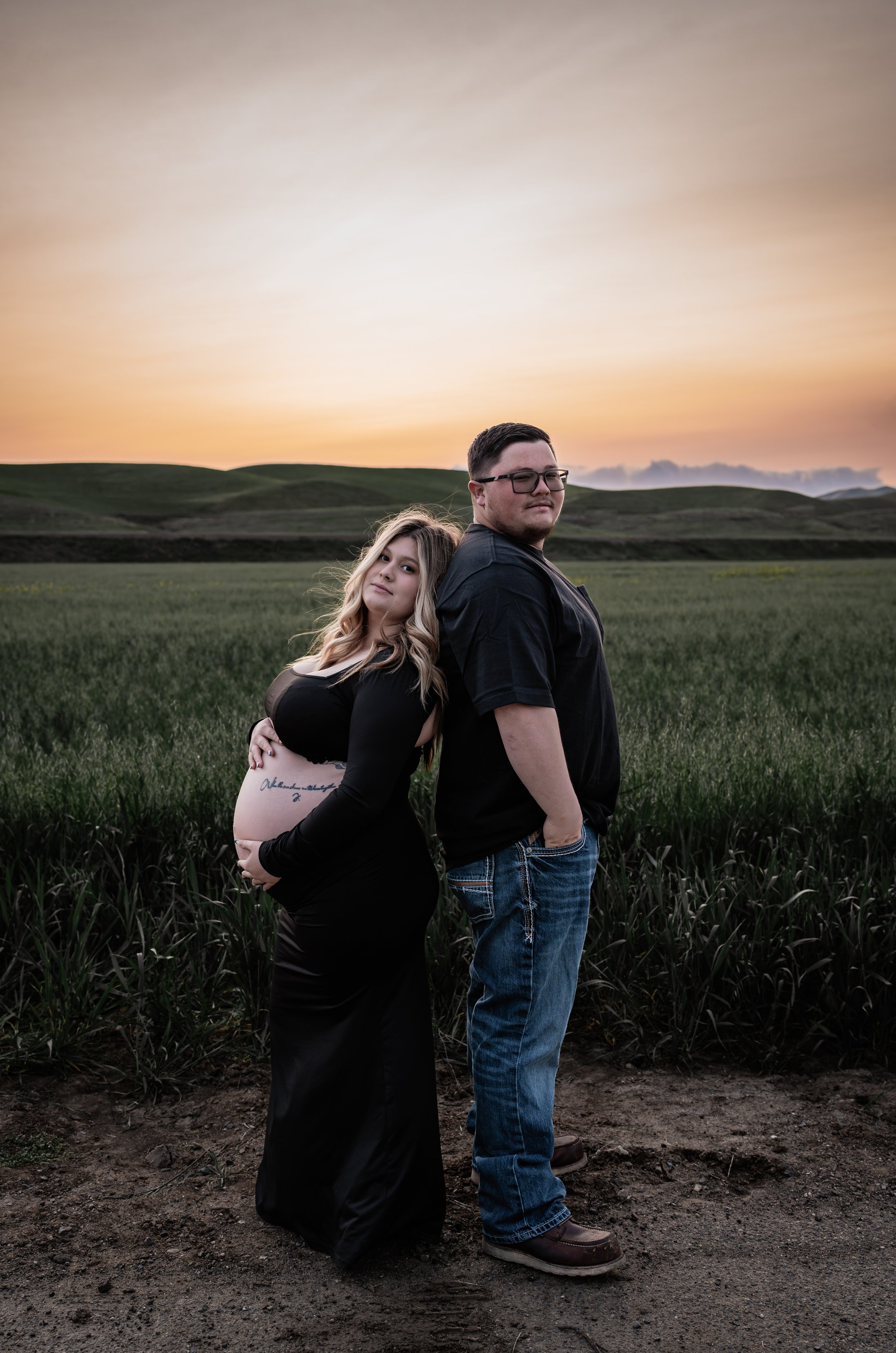 Pregnant mother standing with her partner in an open field. Photo taken in Patterson, CA by Mikaela Tosta Photography.