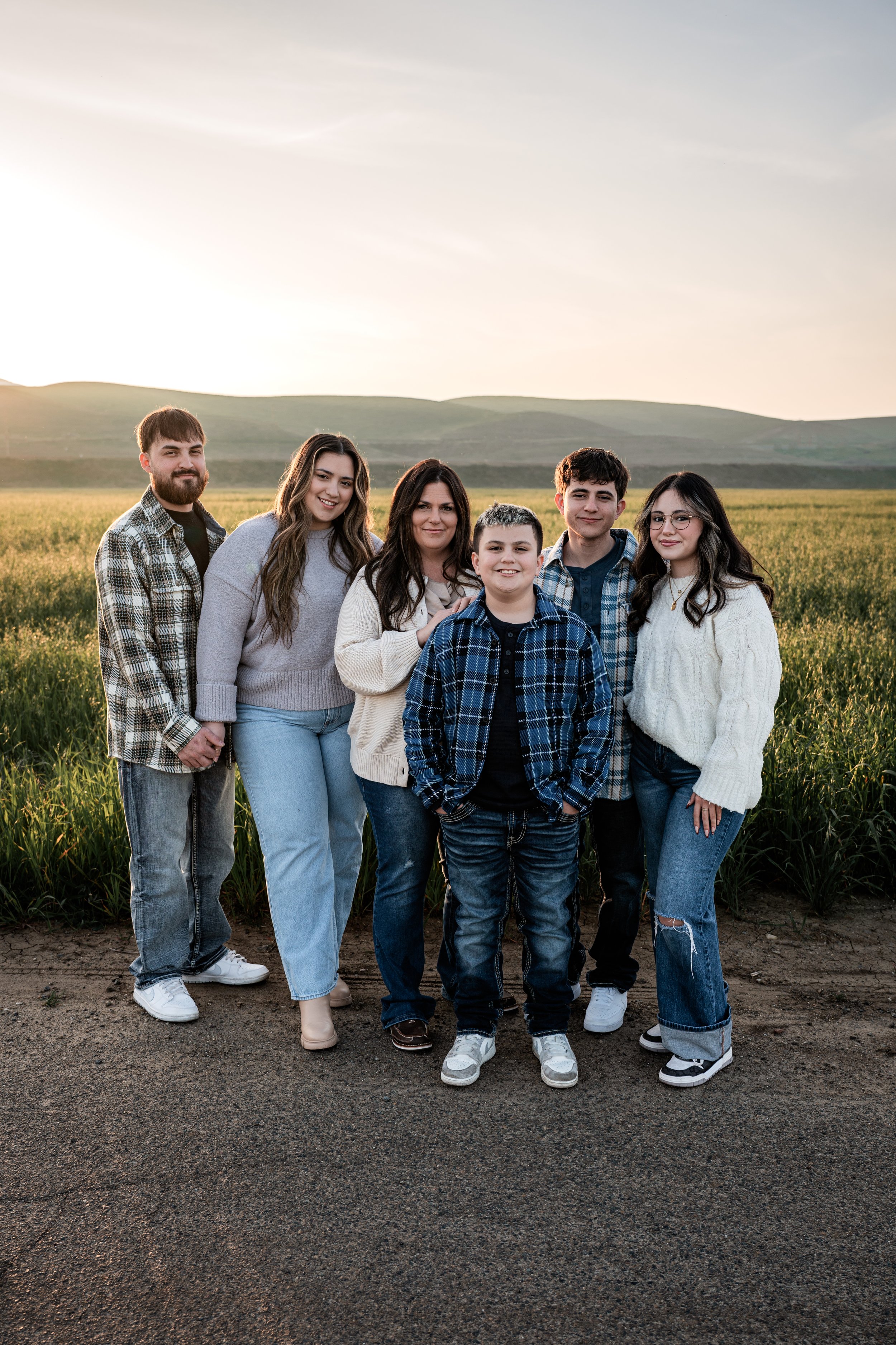 Family of six standing in an open field. Photo taken by family photographer, Mikaela Tosta Photography in Patterson, CA.