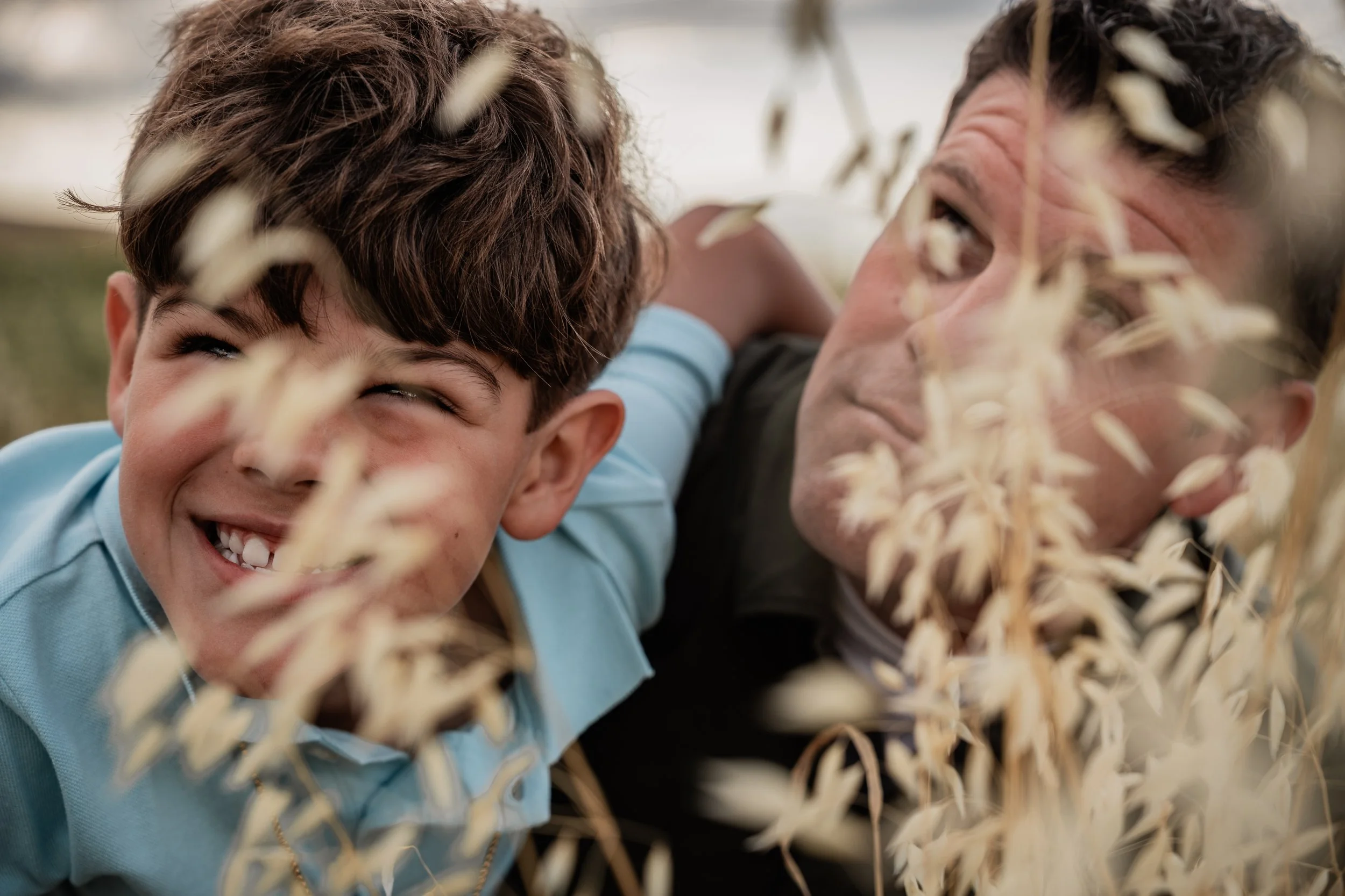 Father and son posing for a silly photo in an open field. Photo taken by family photographer, Mikaela Tosta Photography in Patterson, CA.