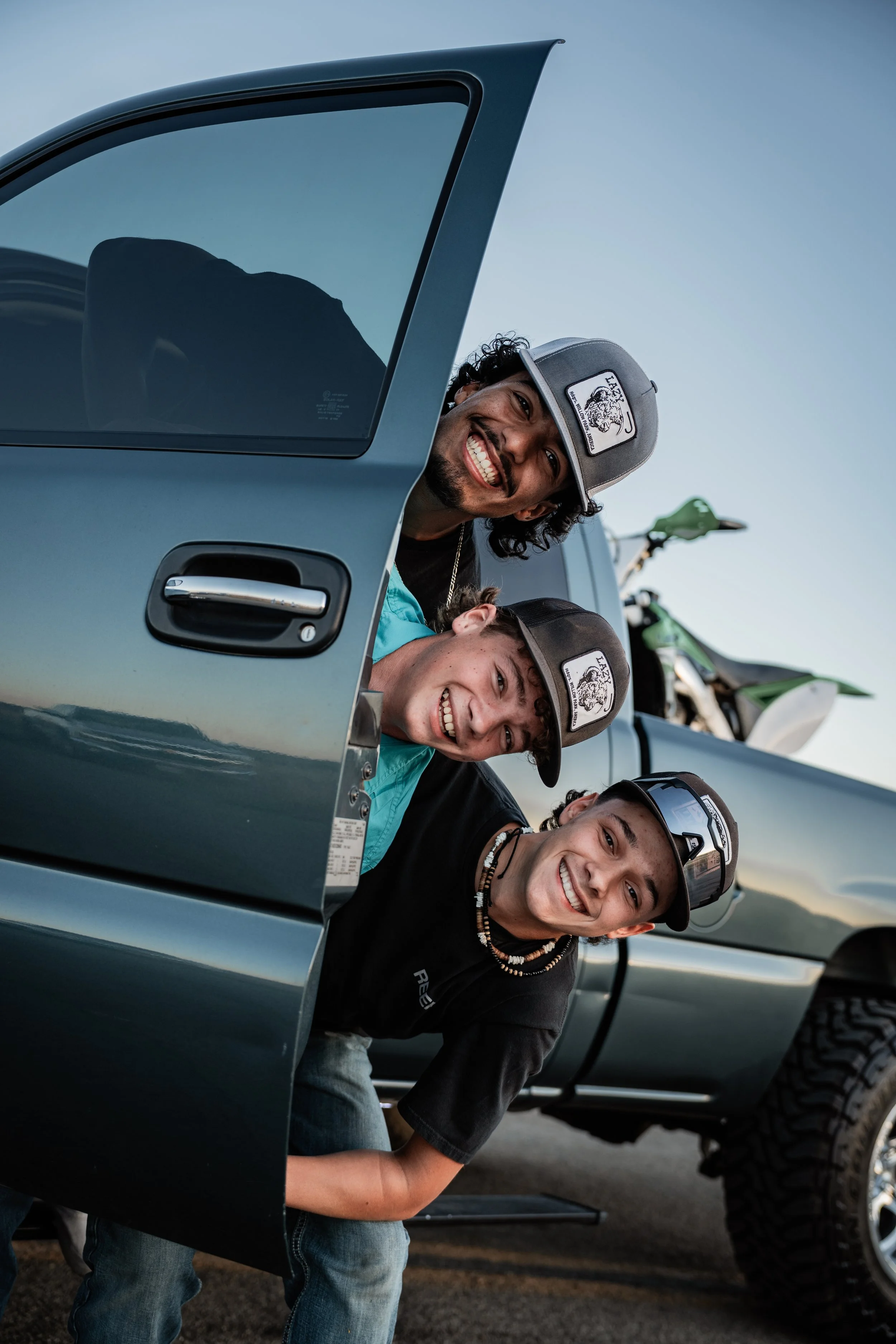 Three boys sticking their heads out on the side of a truck door. Photo taken in Newman, CA by Mikaela Tosta Photography.