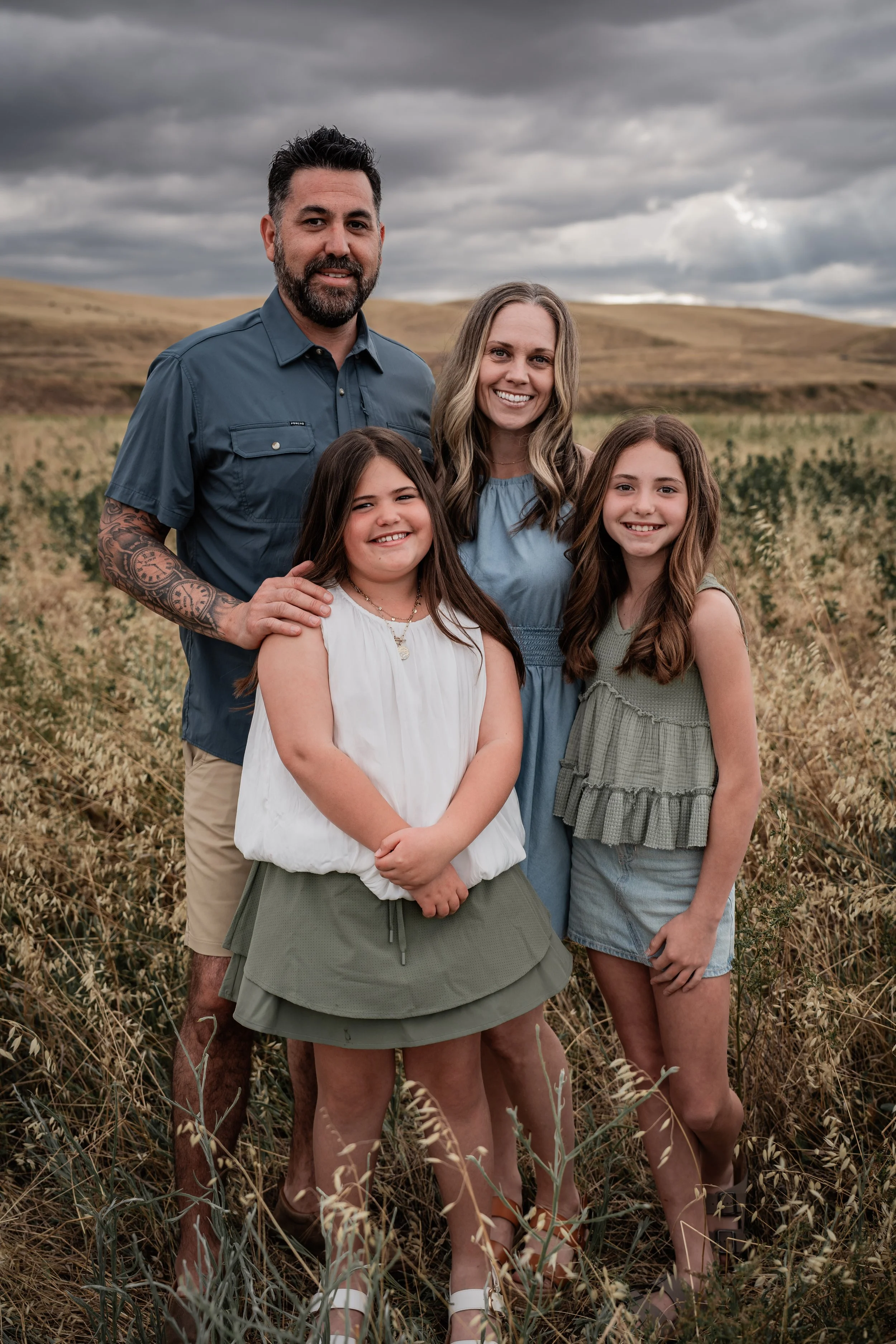 Family of four standing in an open field. Photo taken by family photographer, Mikaela Tosta Photography in Patterson, CA.