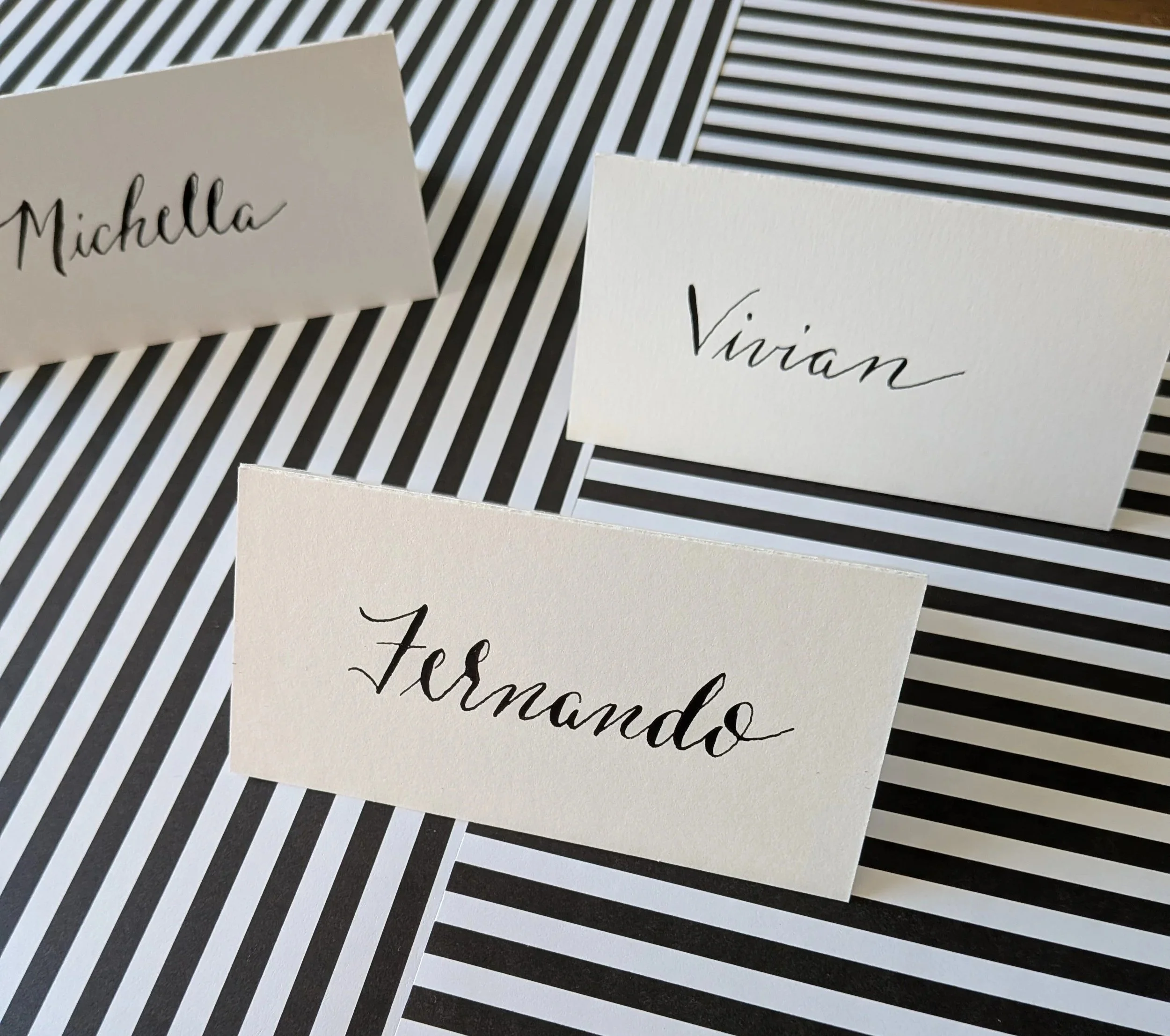 handwritten place cards on black and white striped background for Rhode Island event