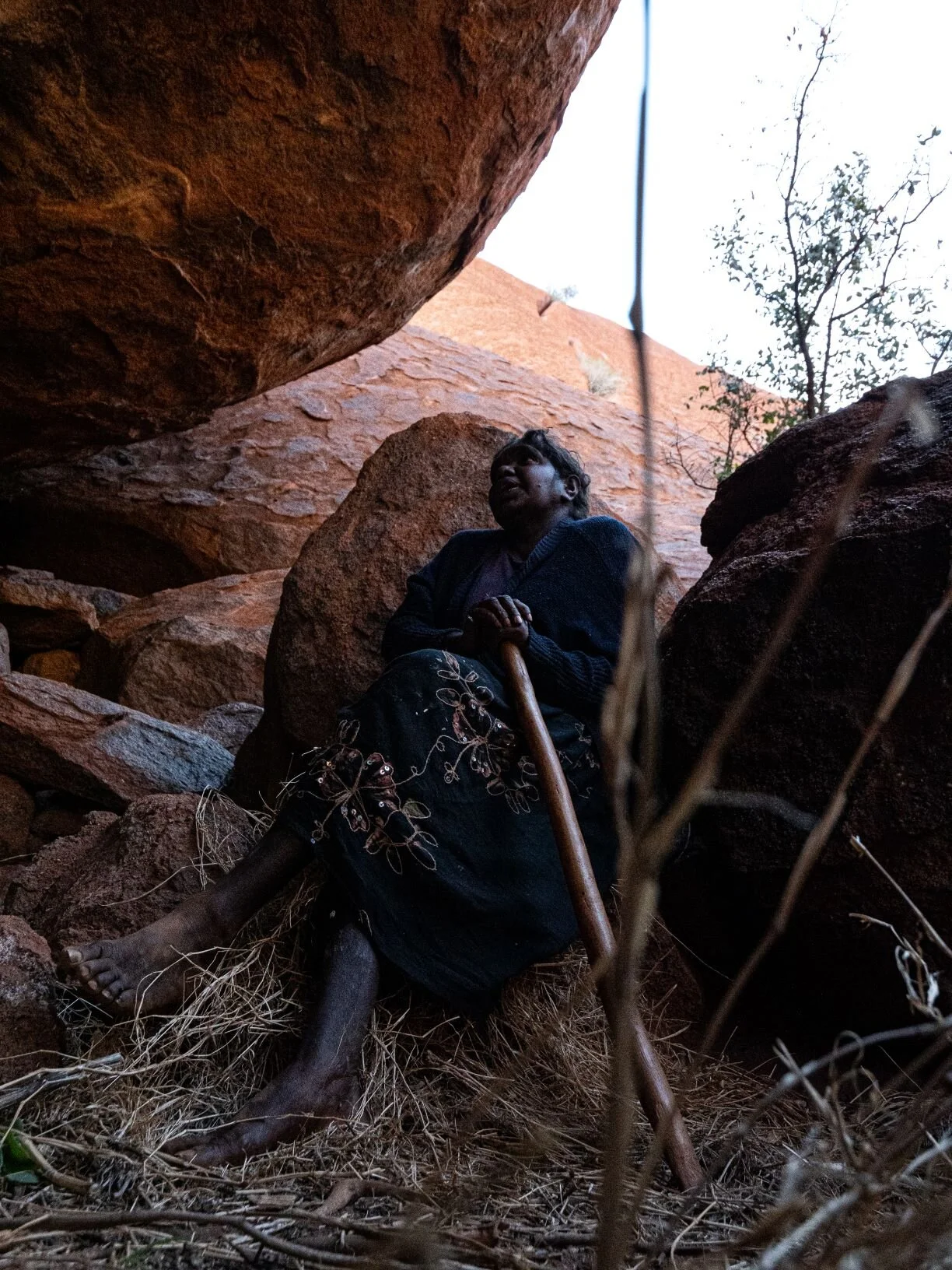  A local Anangu women translates paintings on a cave at Uluru. 