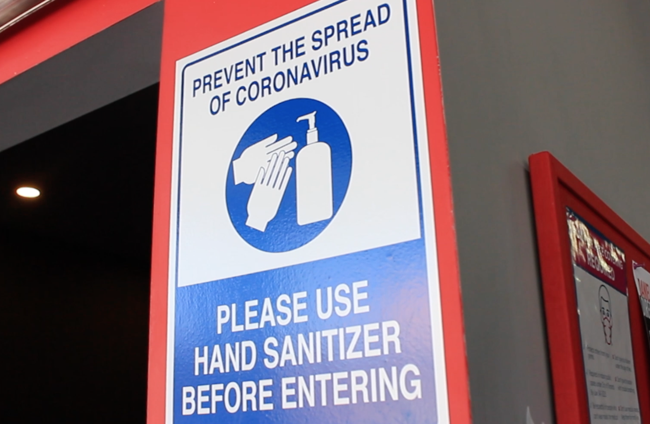 reminders to social distance and sanitize often are pasted all around vive fitness