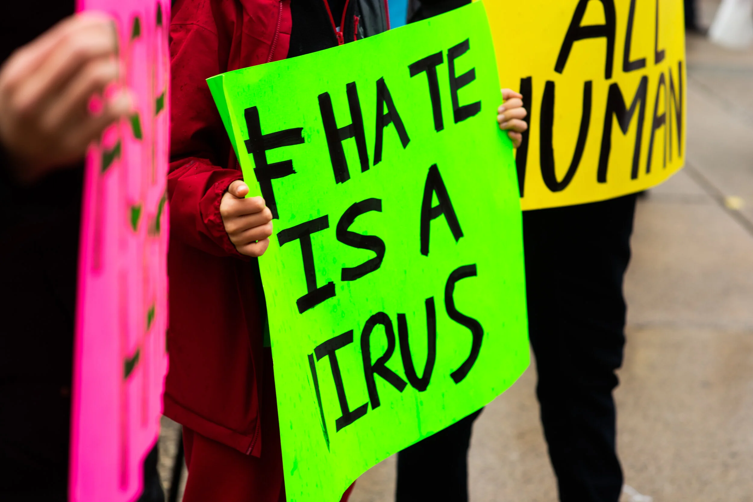 A protester holds a 'Hate is a virus’ sign in Nathan Phillip Square in Toronto for the Anti-Asian Hate protest in April. Photo cred: Johanna Hernandez