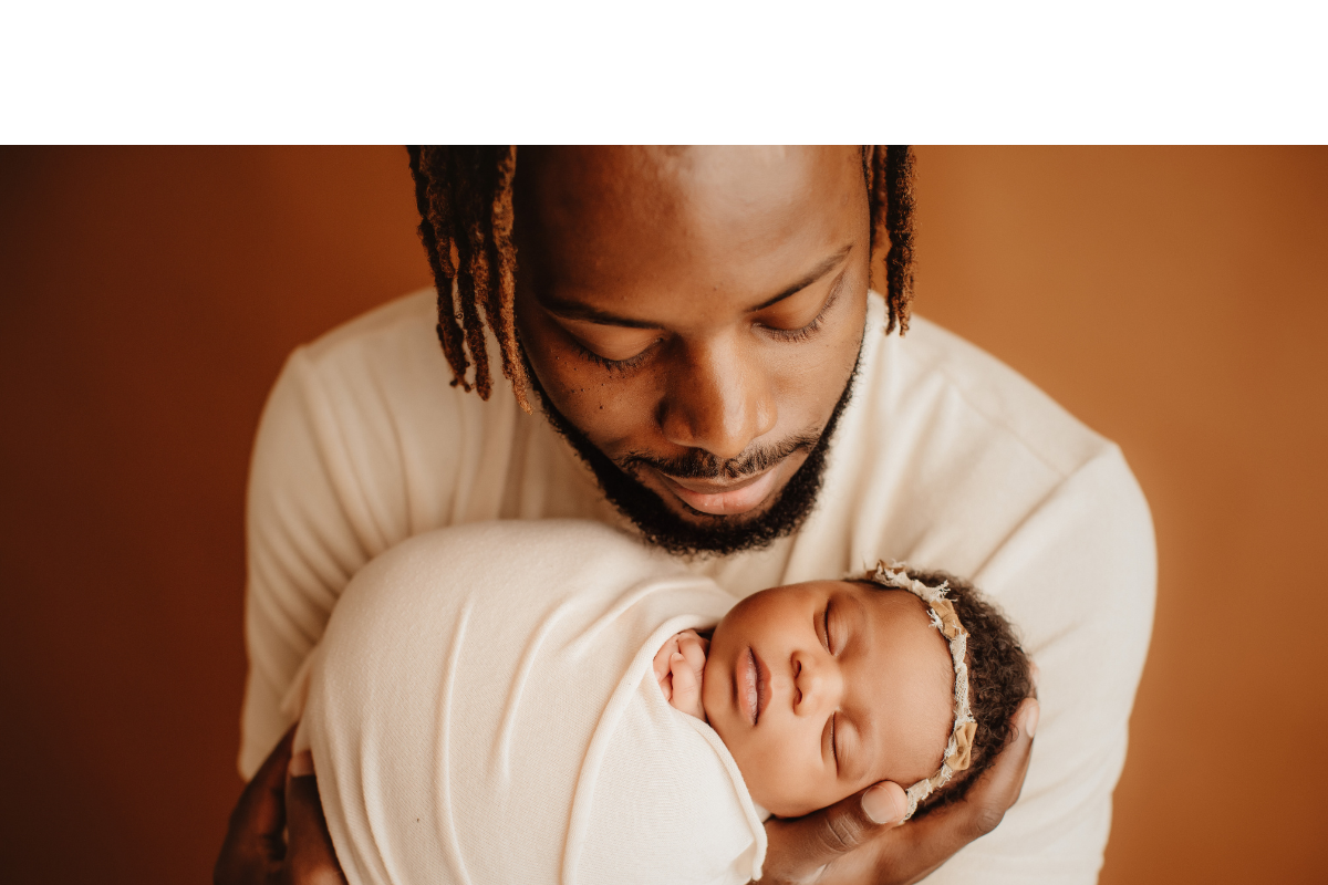 A father holding his newborn daughter. (Courtesy of Canva)