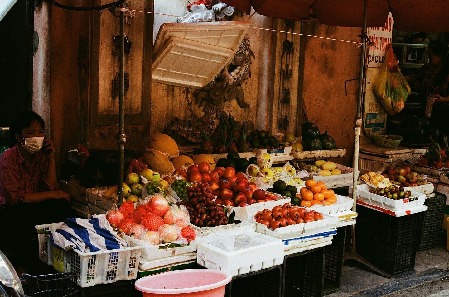 Market fruit stalls, Hanoi, Oct 2023. I love how the colors turned out&mdash;the fruit appears as vibrant jewels sitting pretty in generous piles, lush and tempting on a hot day. Take a few from the first image and place them in a bowl, and they coul