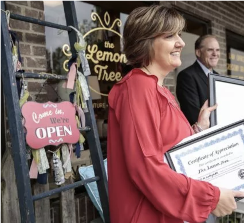 Annie Buchtrup, owner of The Lemon Tree, center, poses for a photo with certifications from the City of South Lyon, Downtown Development Authority, and Oakland County in front of her store on North Lafayette Street in South Lyon.