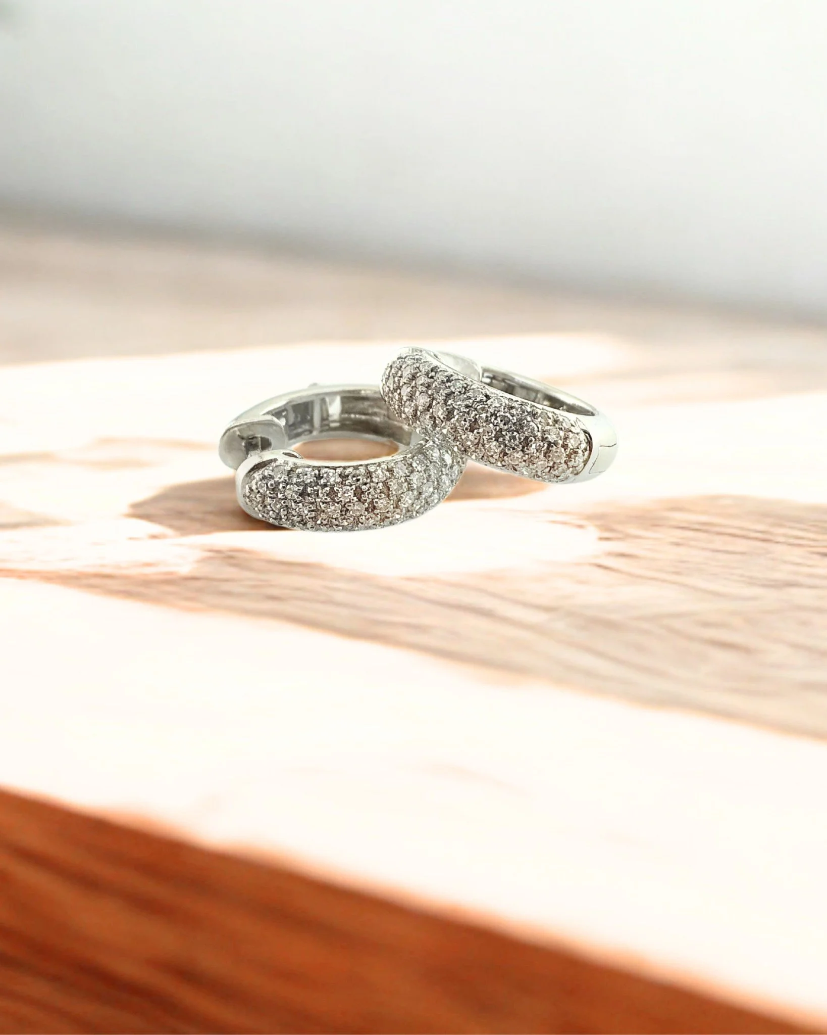 14 karat white gold pav&eacute; natural diamond hinged hoop earrings, featuring a locking safety. Perfect for dressing up or everyday wear, these classic earrings are sure to turn heads with their brilliant sparkle.