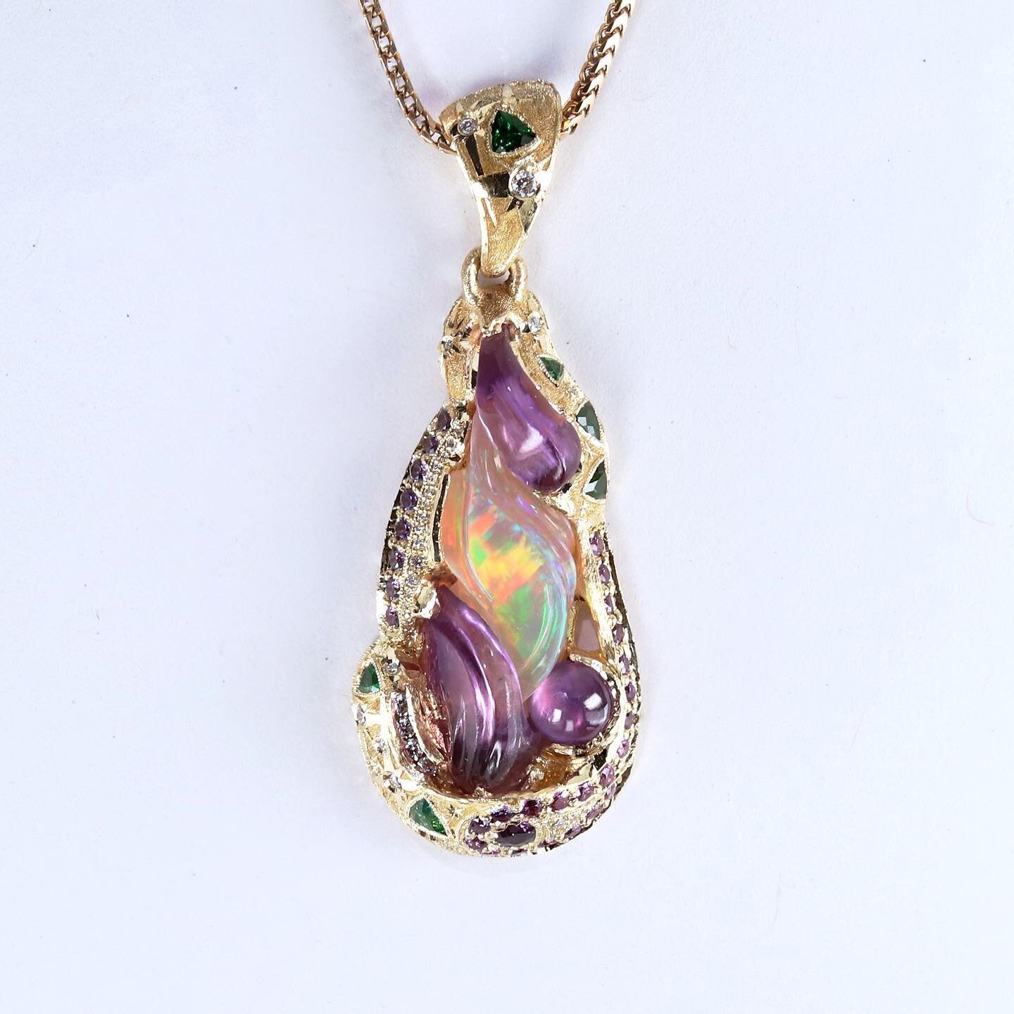 So happy to present this super special and gorgeous unicorn vibe inspired pendant! Cast in 18k gold, this whimsical piece features a 2.91ct opal, 3.07ct amethyst (all carved in house) along with 1.18ct of purple sapphire, .31 ct tsavorite, .13ct diam