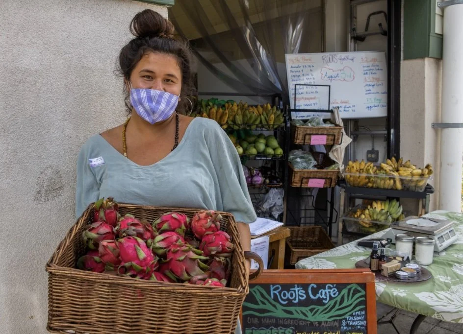 Staff member at Roots Café & Food Hub with locally grown produce