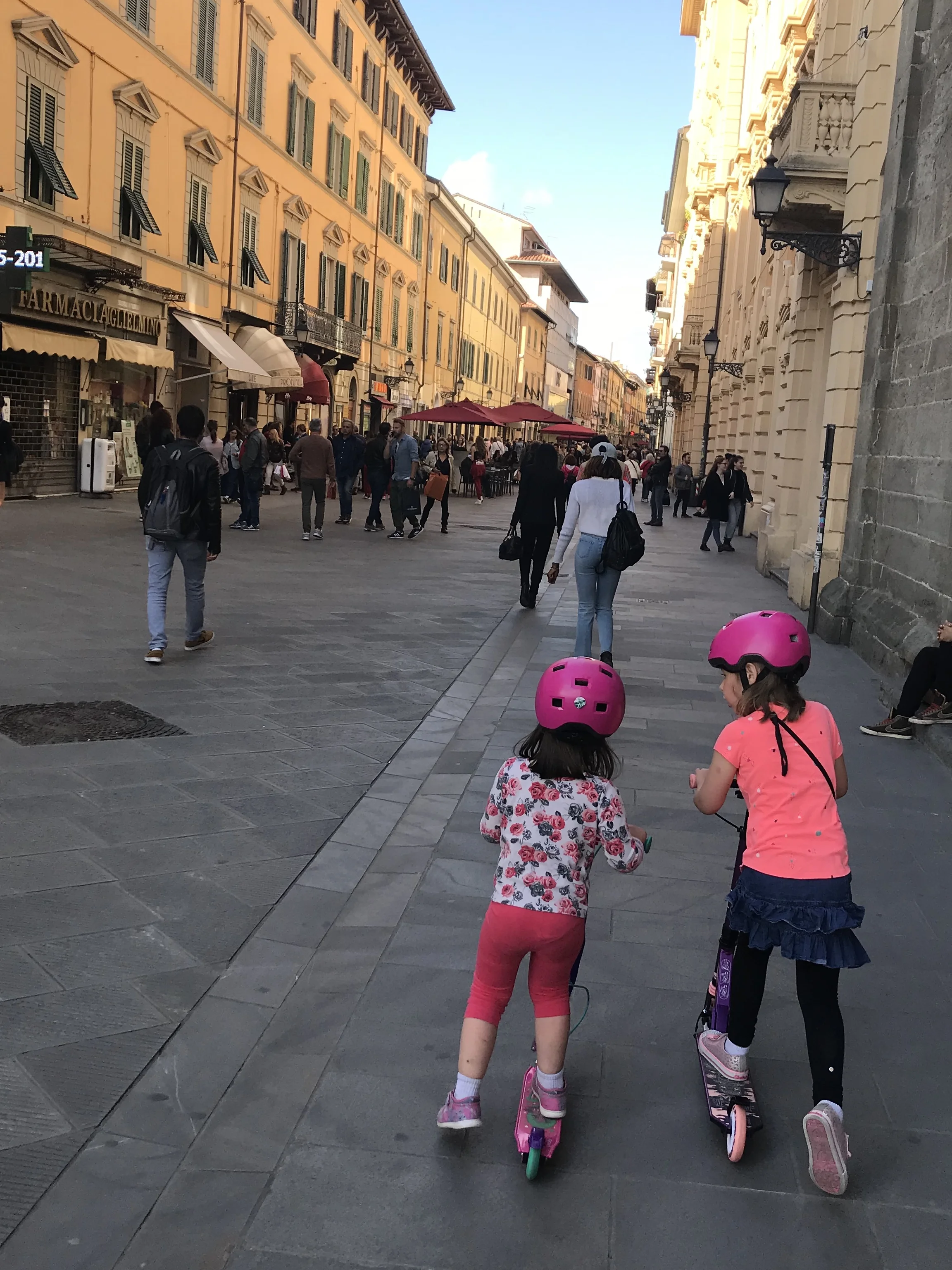 Our little ones riding their scooters in Pisa