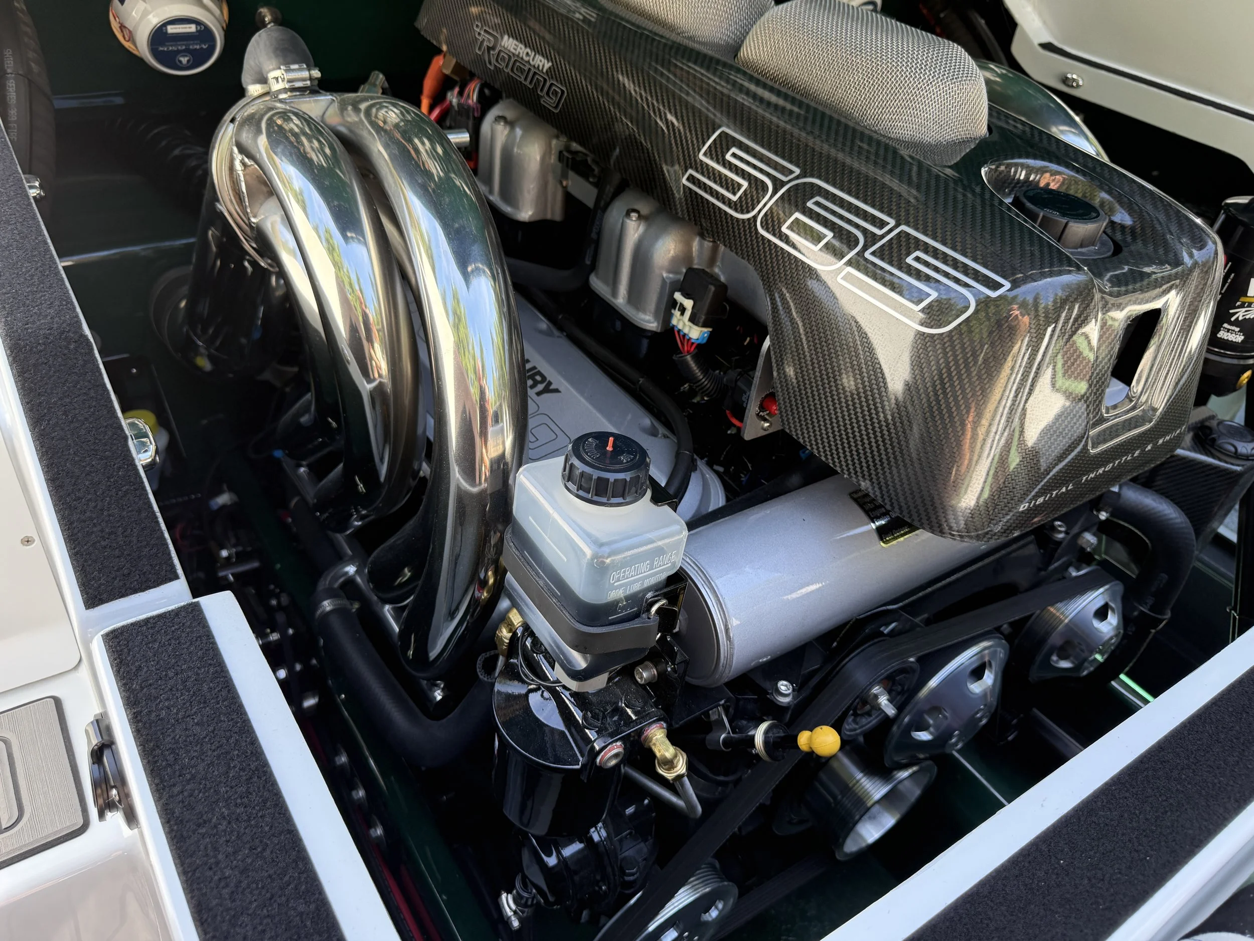 Close-up of a race car engine with shiny metallic parts, including a carbon fiber component with the word 'LTD' and 'Mercury Racing' labeled on it.