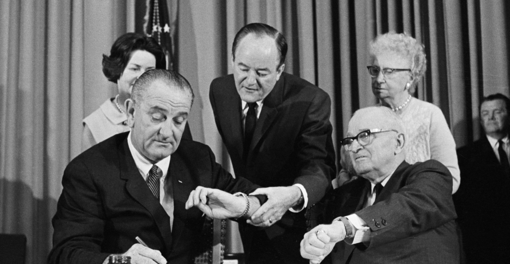 Lyndon B. Johnson signing Medicare into law on July 30, 1965