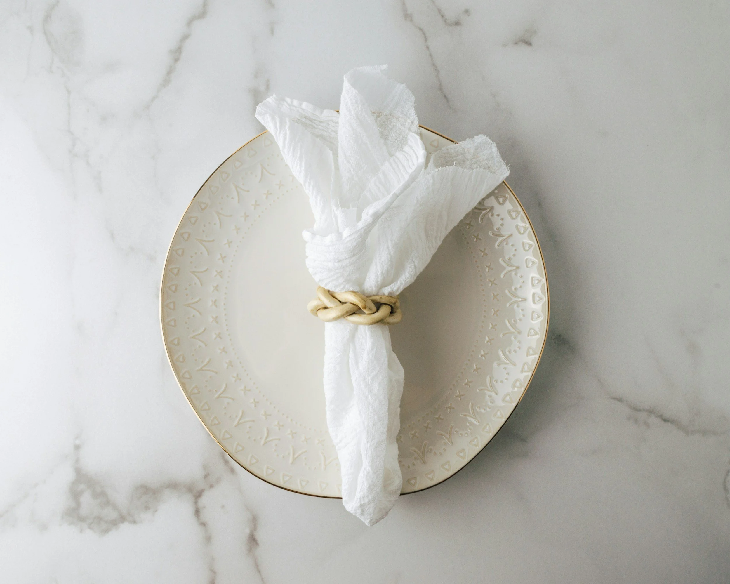 white napkin on a white patterned plate