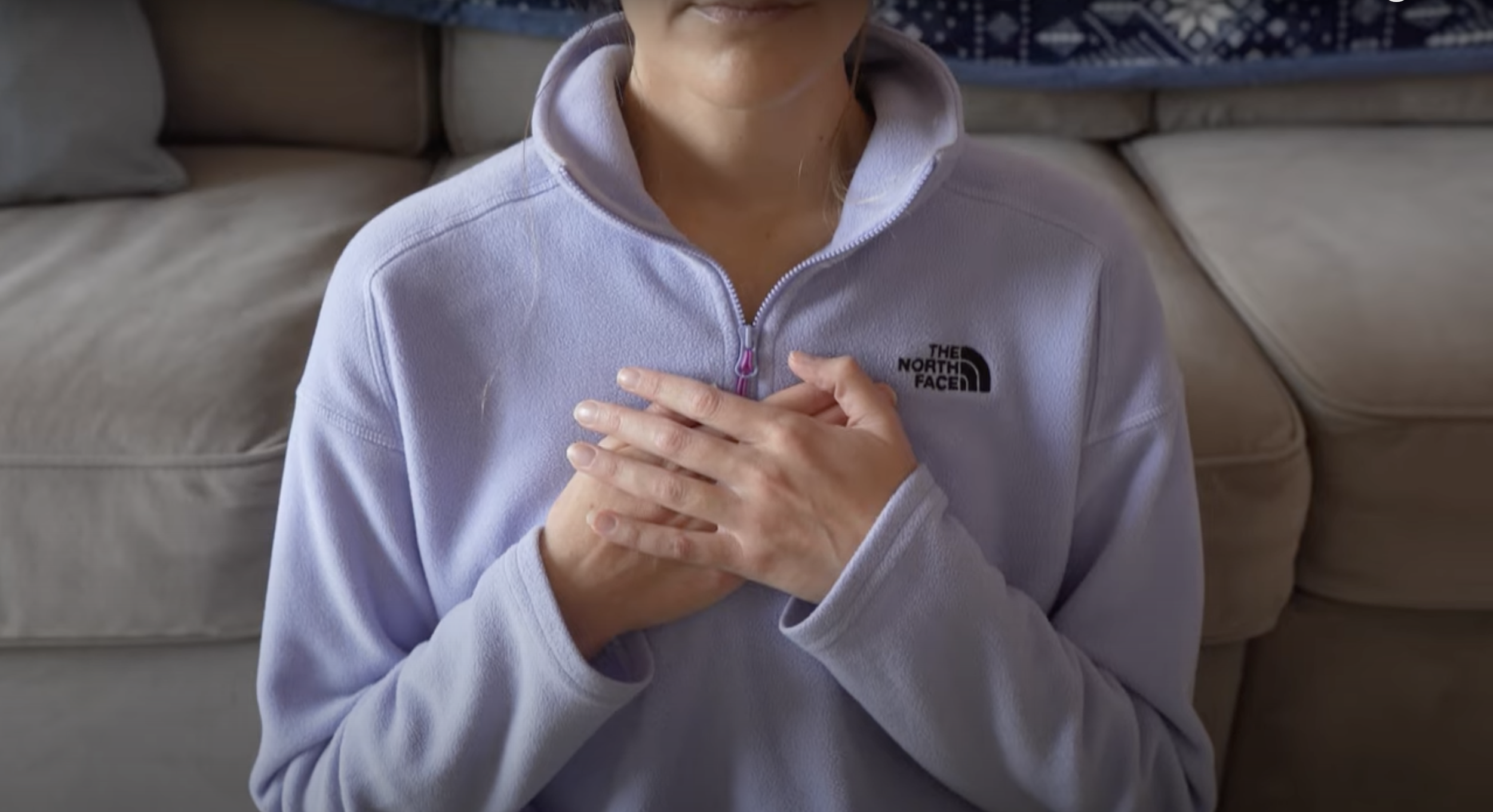Person with hands clasped over their heart practicing self-Reiki