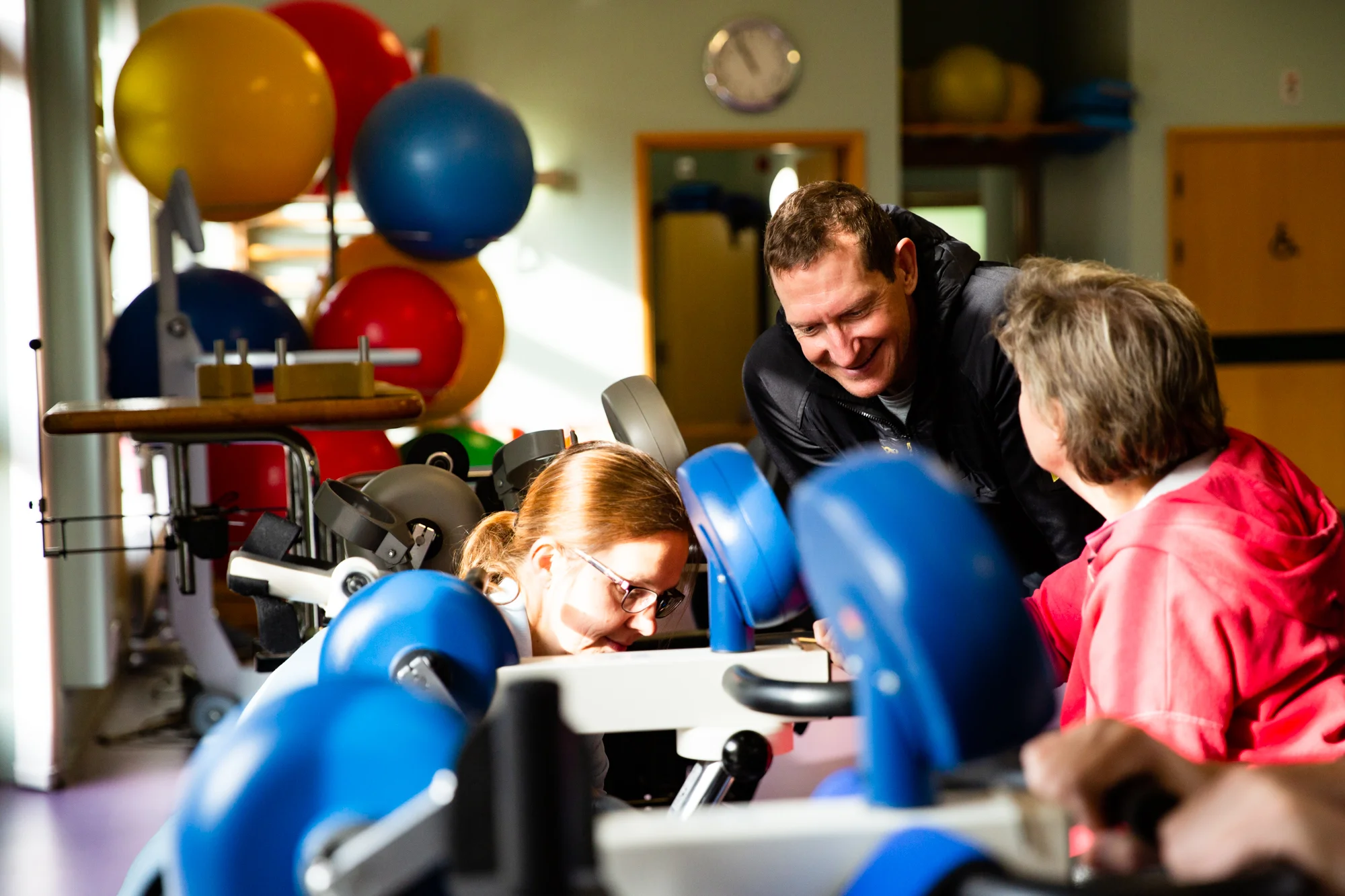 Cameron chats to Bev while she is being set up on the static cycling machine. It automatically adjusts to effort, so when you tire, it keeps your limbs moving.