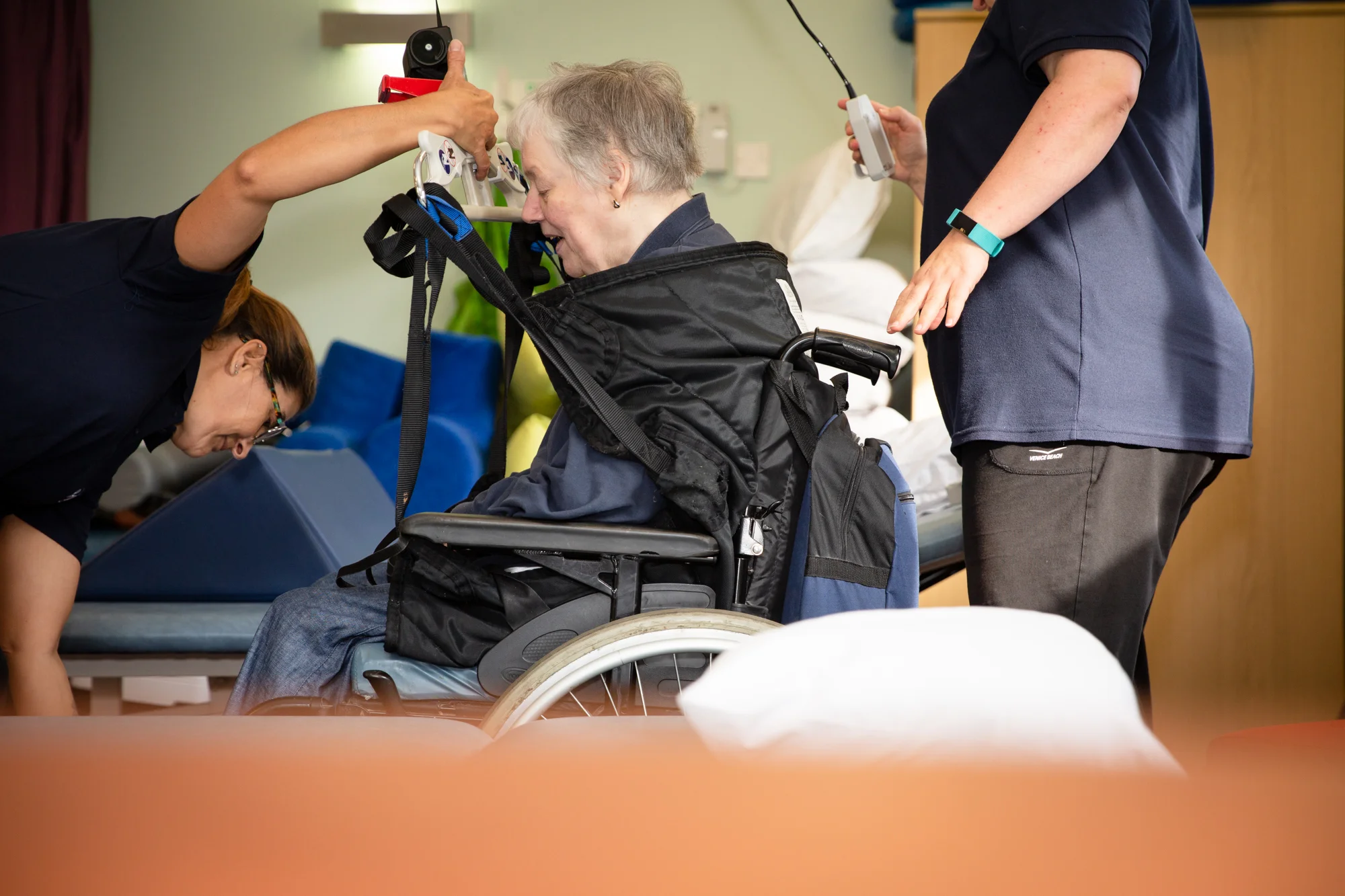 Deirdre being ‘air lifted’ onto a treatment bed so she can begin physiotherapy treatment.
