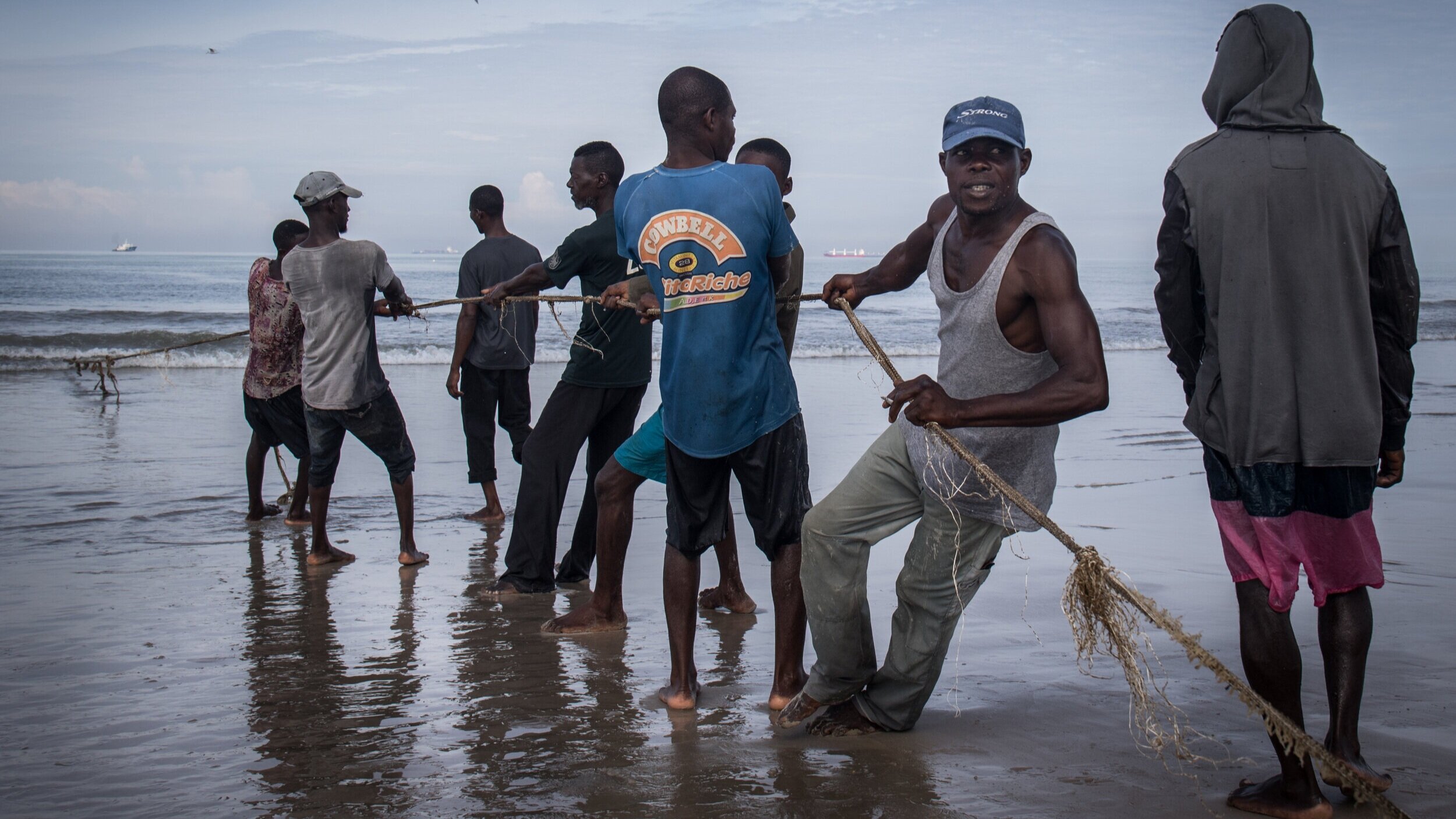   Artisanal fishermen pull in a pirogue in Pointe-Noire, Republic of the Congo  