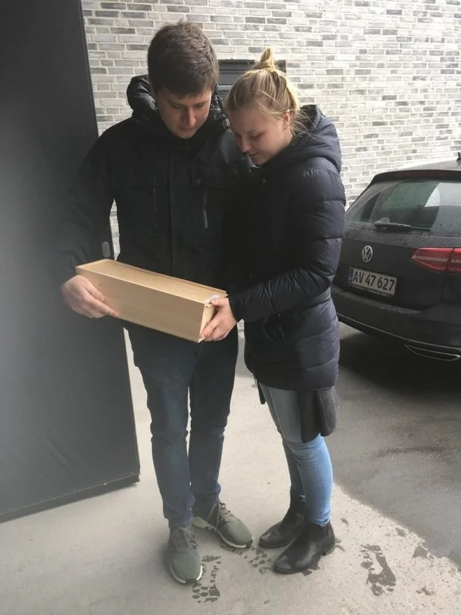 Billede af os med Theos kiste foran krematoriet og os bag hans urne i kapellet inde mindehøjtideligheden