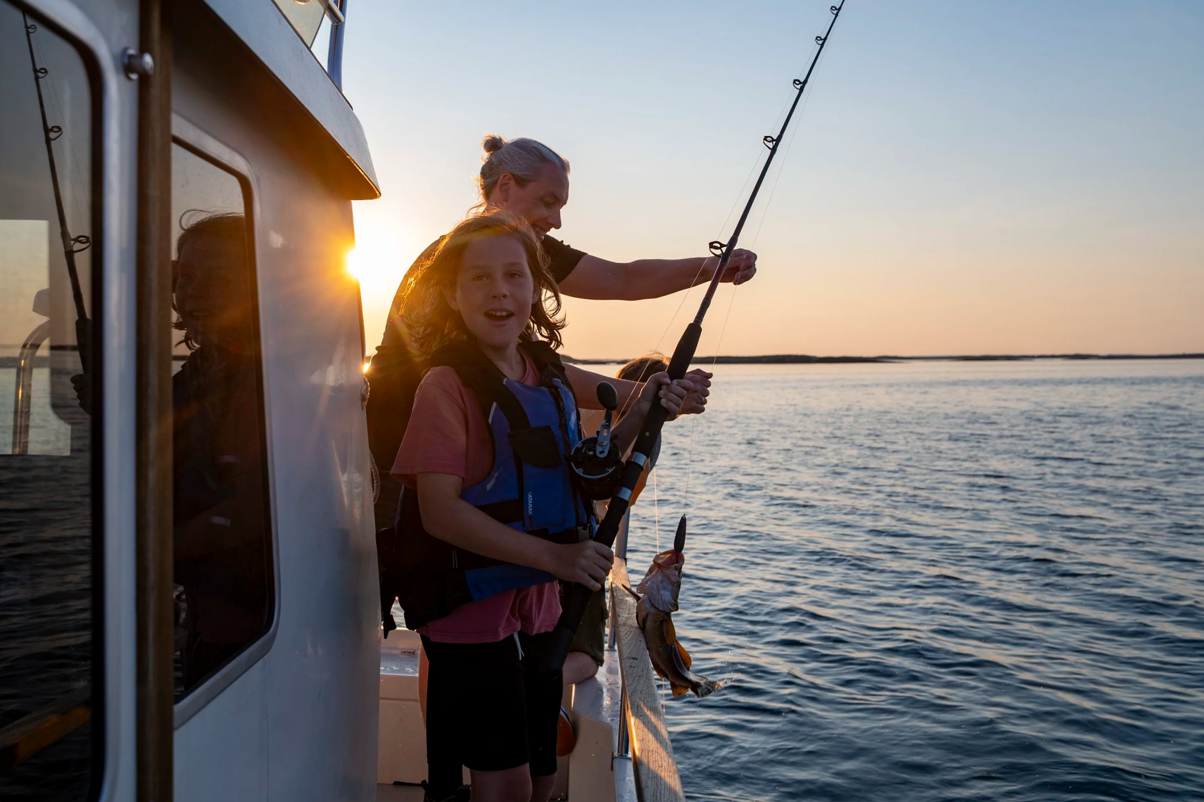Fisketur fra båt med stang, en sommerkveld