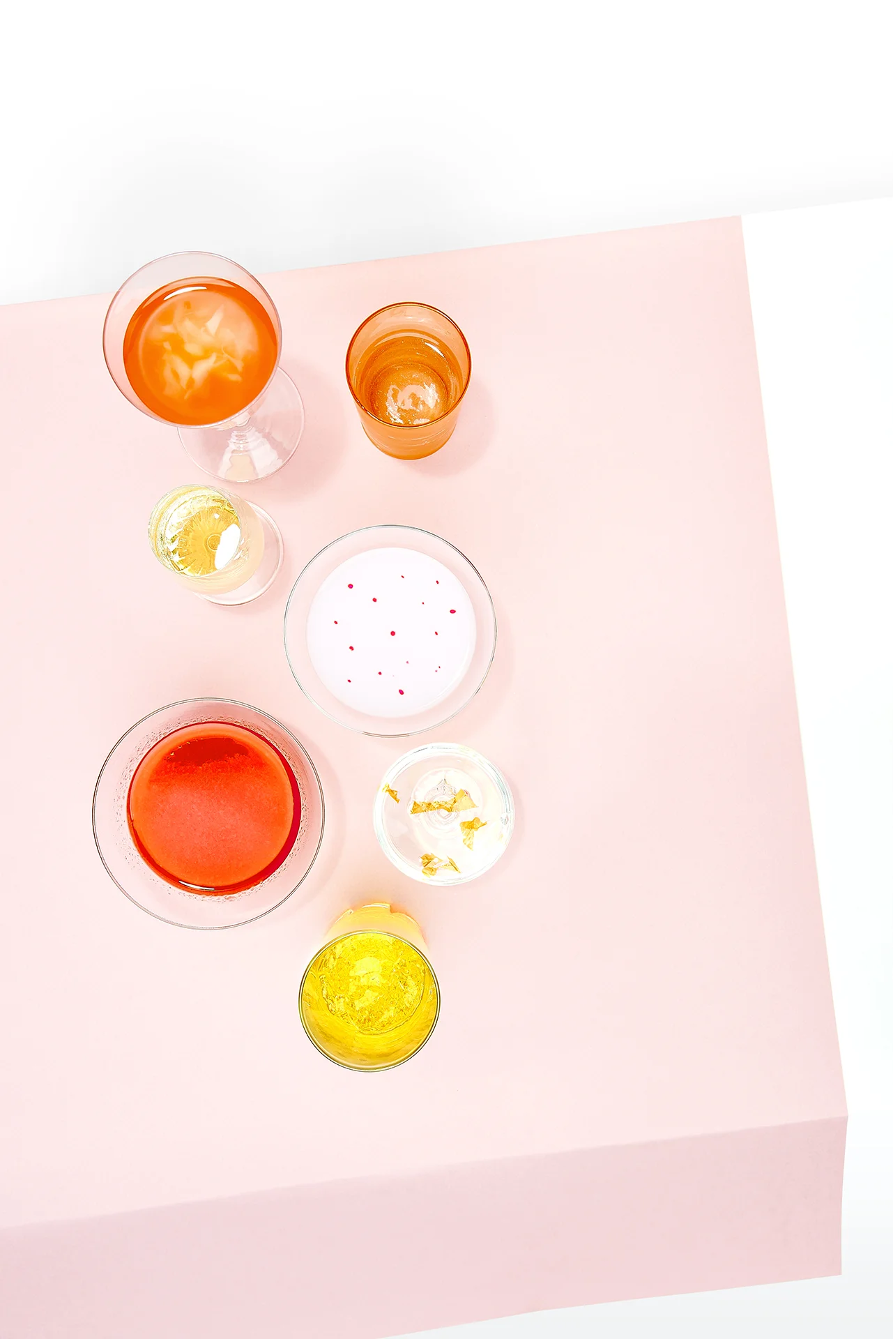  A topshot of a collection of glasses, filled with different liquids 
