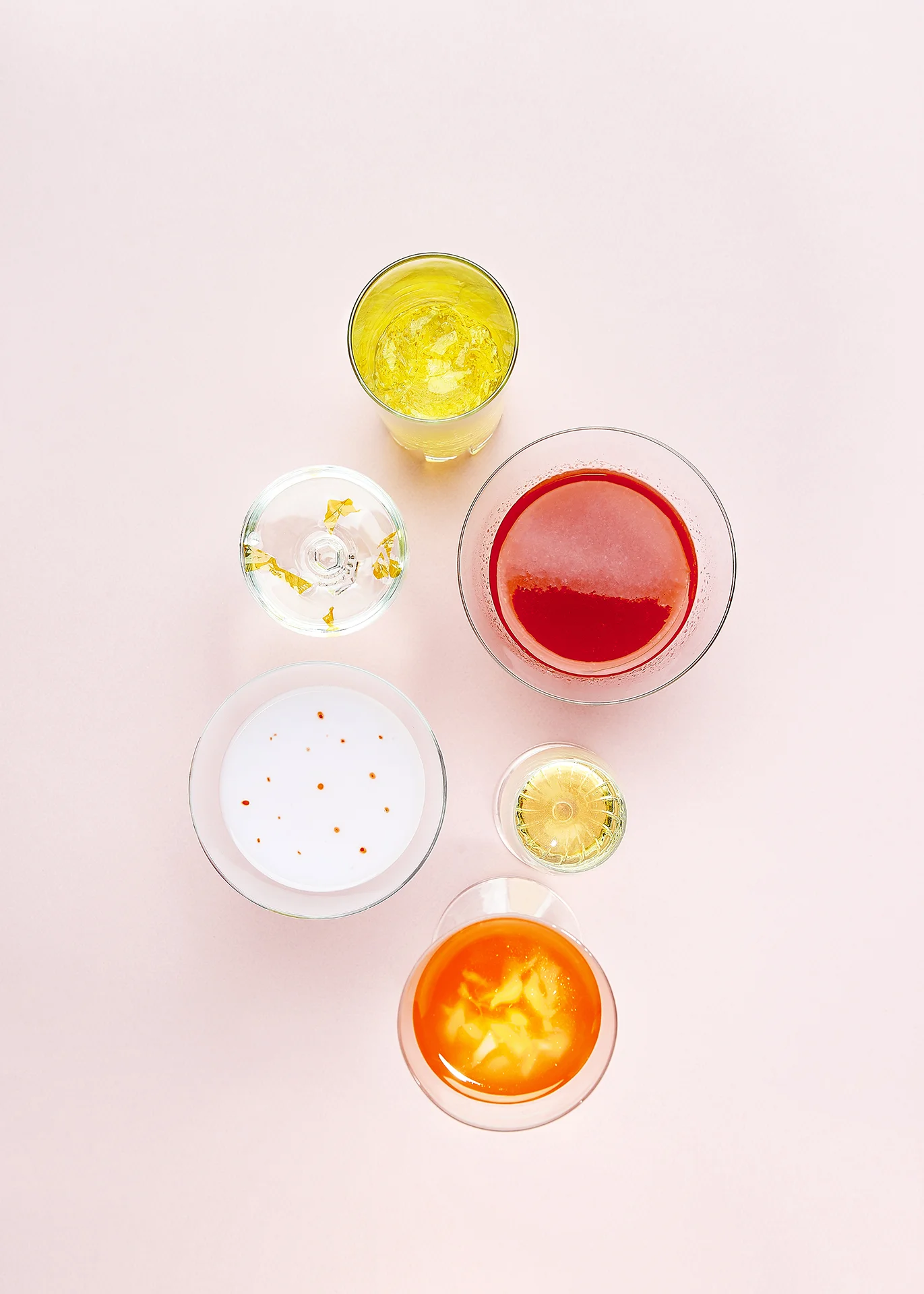  A topshot of a collection of glasses, filled with different liquids 
