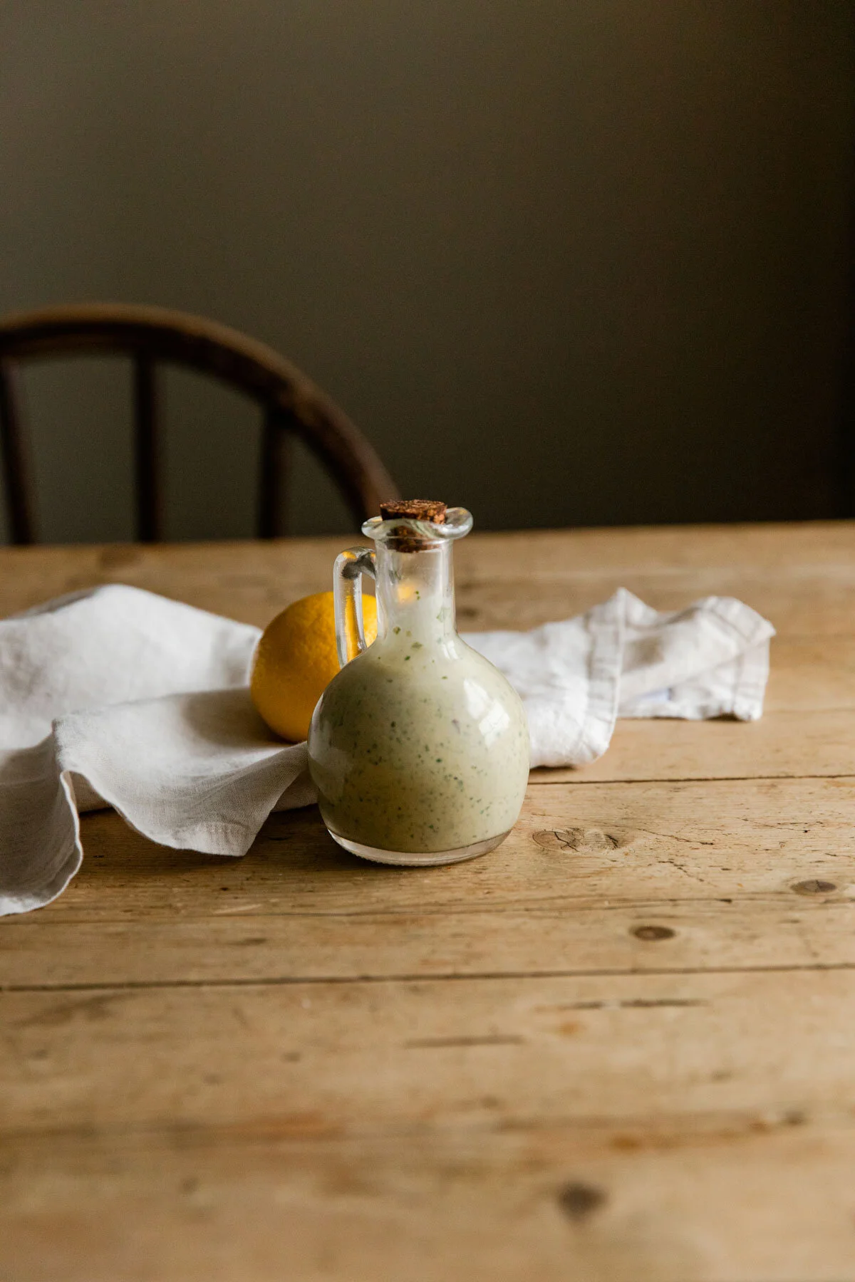 Herby tahini dressing on table with lemon