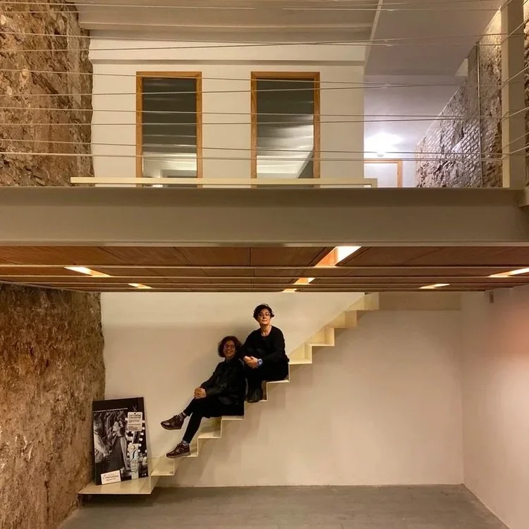 Las fundadoras de The Others Pharmacy, sentadas en una escalera