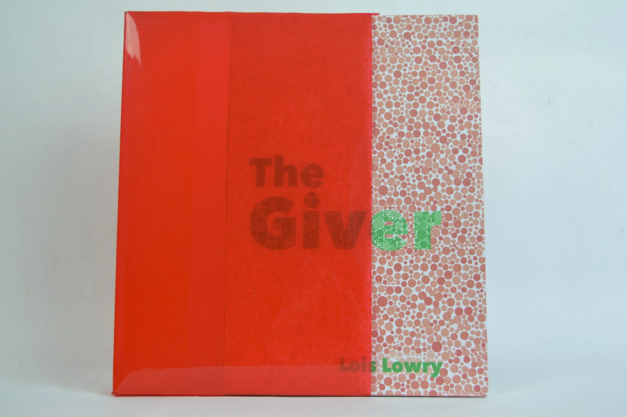  This cover mimics the Ishihara colorblind tests. It uses a variety of dots which is similar to how the tests work. The jacket is made of plastic binder inserts in order to give it the transparent look that it needs.&nbsp; 