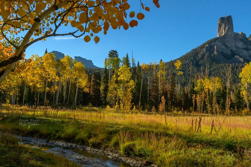 Golden autumn aspens surround Deb's Meadow beneath Chimney Rock along Owl Creek Pass in Colorado.