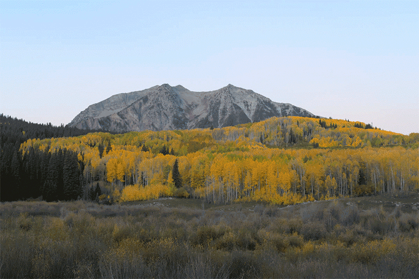 Sunrise light changing over the autumn landscape along Kebler Pass near Crested Butte, Colorado.