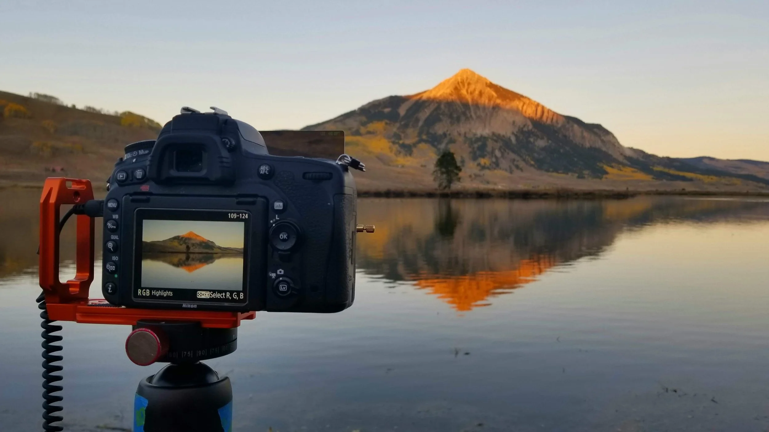 Camera photographing a mountain reflection during in-the-field landscape photography training.