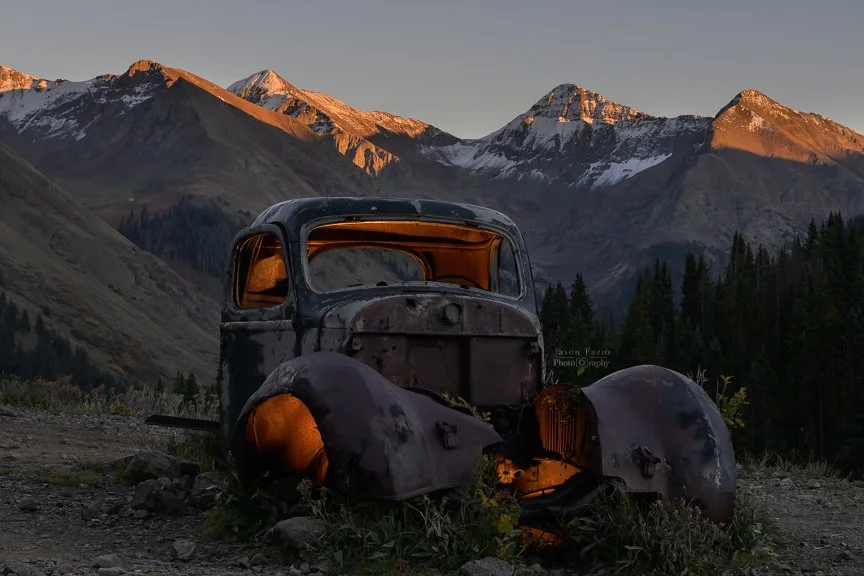Abandoned old truck at Animas Forks Ghost Town with sunset light on the San Juan Mountains near Silverton, Colorado.
