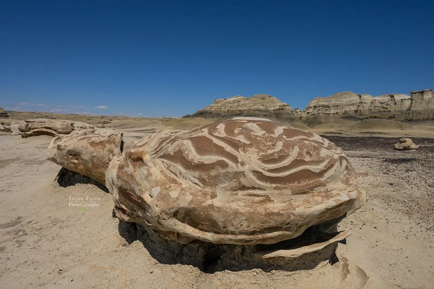Jason Fazio Photography's overall image showing rock formations with swirled design patterns in front of a clear blue sky.