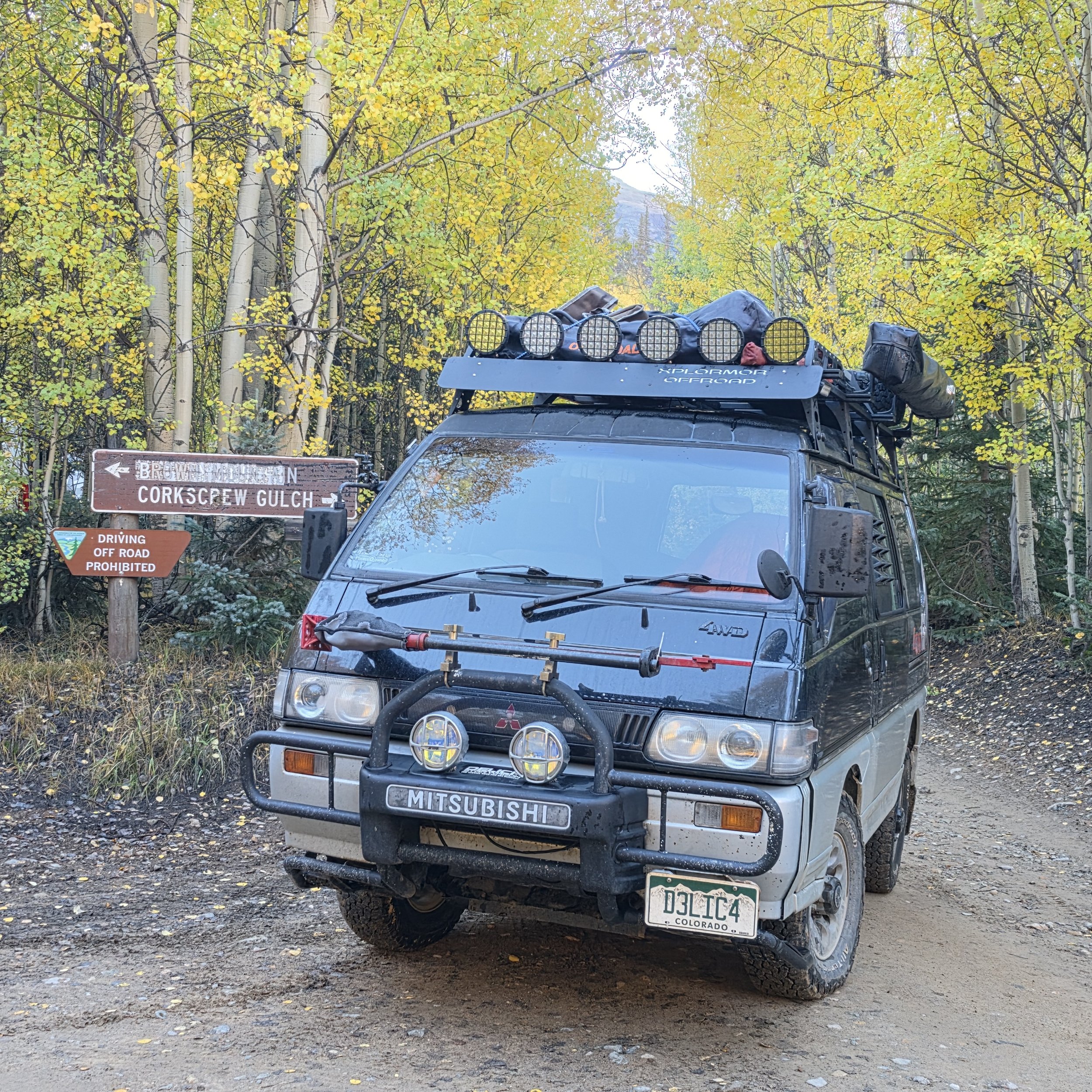 Mitsubishi Delica parked beside the Corkscrew Gulch sign after descending Corkscrew Pass near Silverton, Colorado.