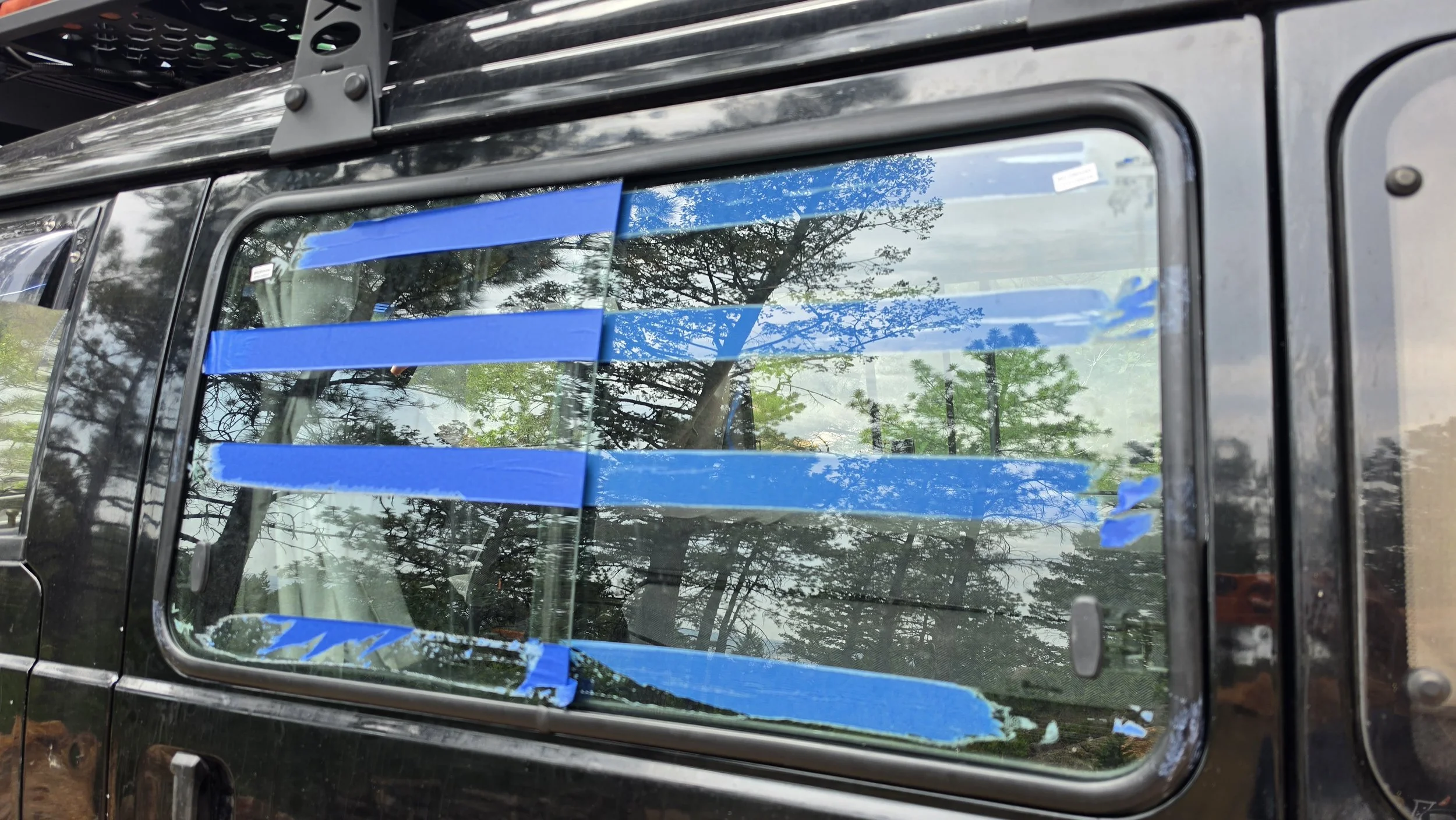 Sliding windows installed on the Mitsubishi Delica L300, aka the Five Billion Star Hotel, showing them on the correct side and with tape on them.