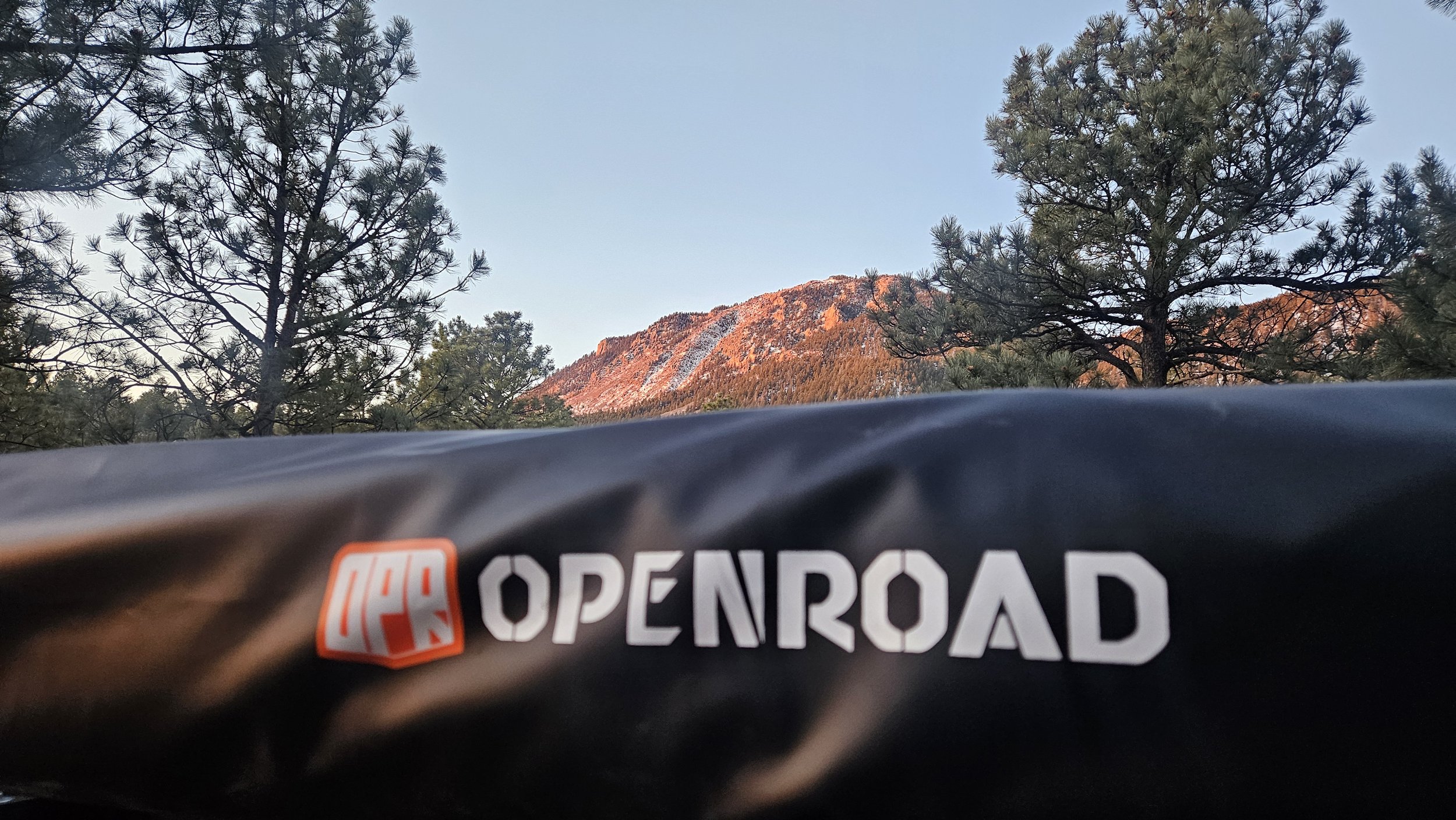 OPENROAD logo on the protective cover of an Adventure Series 270-degree awning mounted to a Mitsubishi Delica L300.