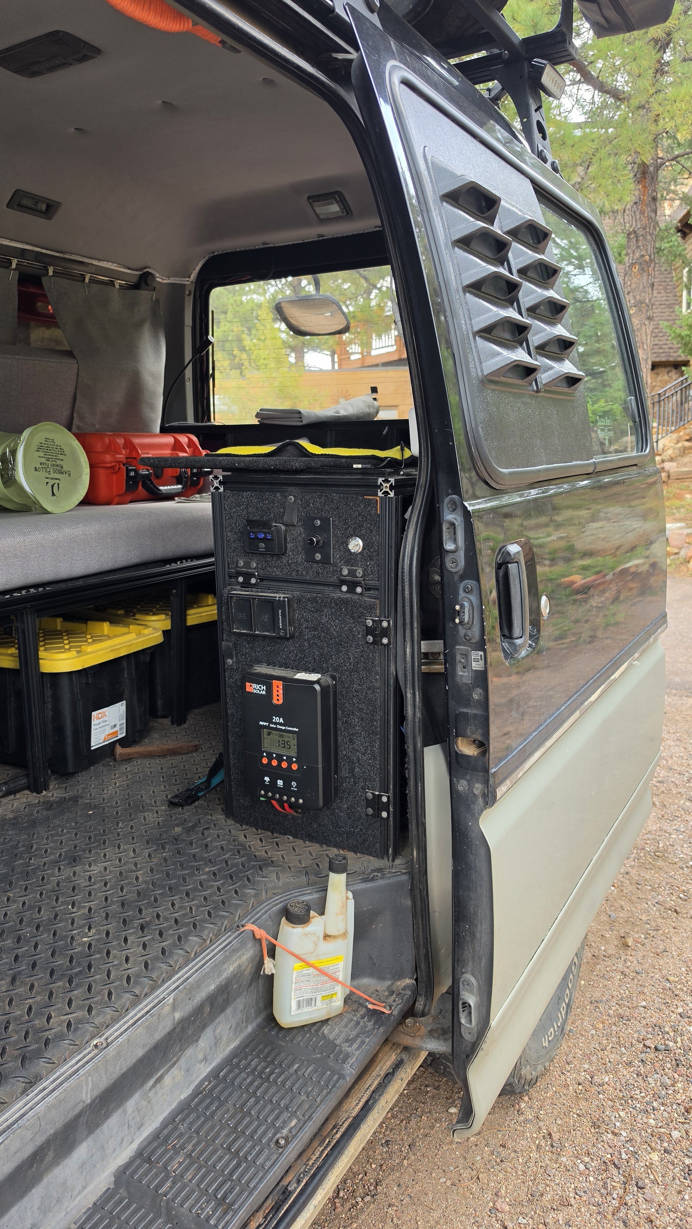 House-power system mounted inside the passenger-side sliding door of a Mitsubishi Delica L300, providing USB power for the OPENROAD awning lights.