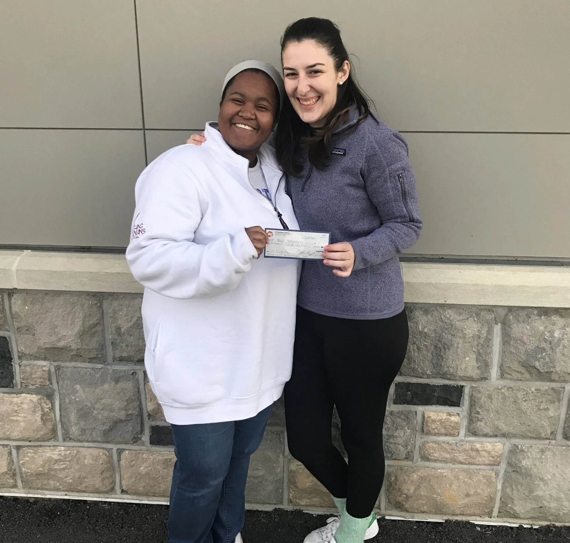 Maya Williams (left) receiving the check from Katie Rizzolo (right); Source: Ashley Deans