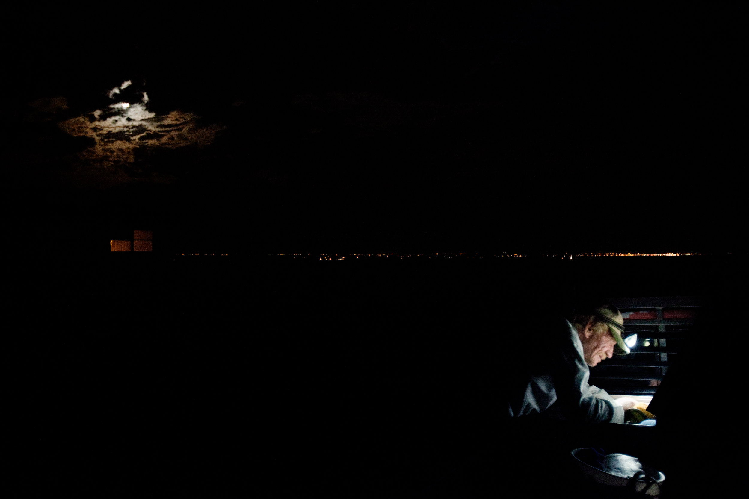  A man works on his truck outside of the trailer where he stays in Pajarito Mesa, New Mexico, USA on May 28, 2010. While residents of the Pajarito Mesa legally own their land, a bureaucratic oversight has prevented them from receiving paved roads, ru