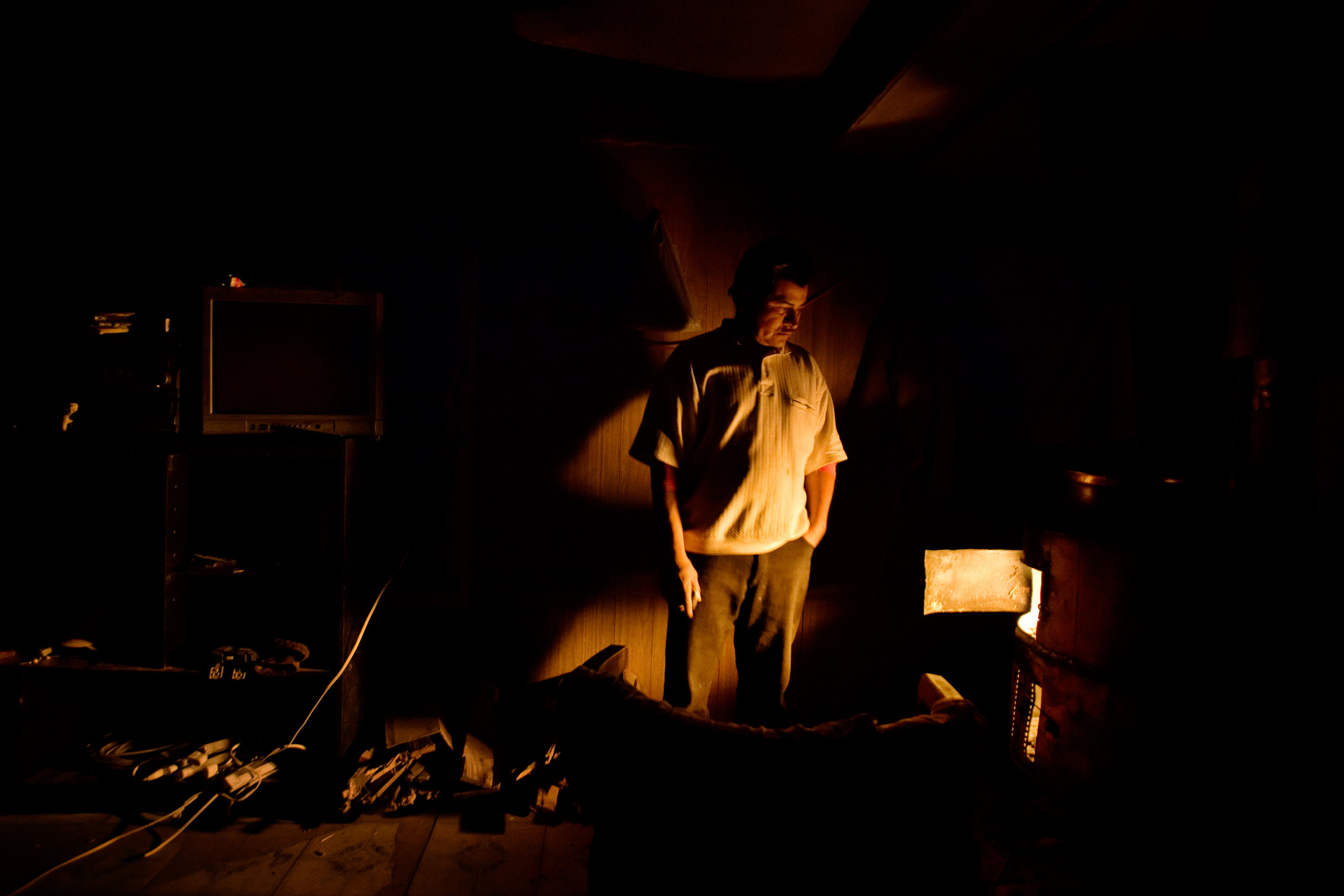  Epifanio Alcudia stands by the heat of a wood stove in his trailer in Pajarito Mesa, New Mexico, USA on Feb. 8, 2011. 