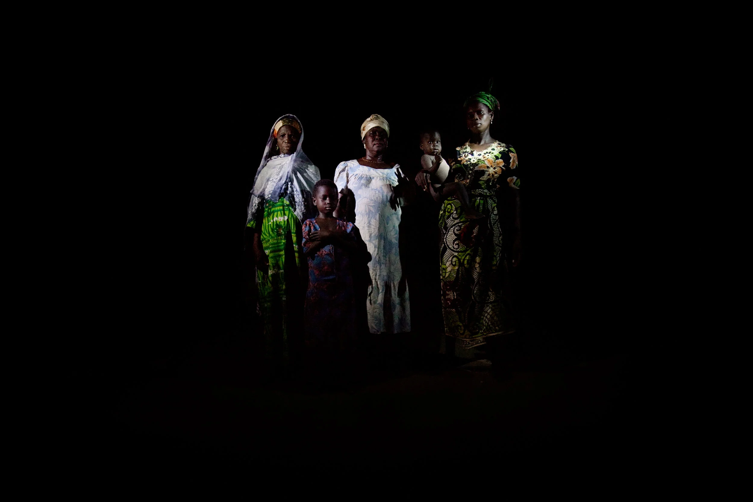 The women and children of the Abubakari household pose for a portrait lit with flashlights in Voggu, Northern Region, Ghana on Feb. 20, 2010. Women bear the heaviest burden of living without electricity, as they walk for miles to fetch firewood and bring grains to nearby villages to be processed by electronic machinery.