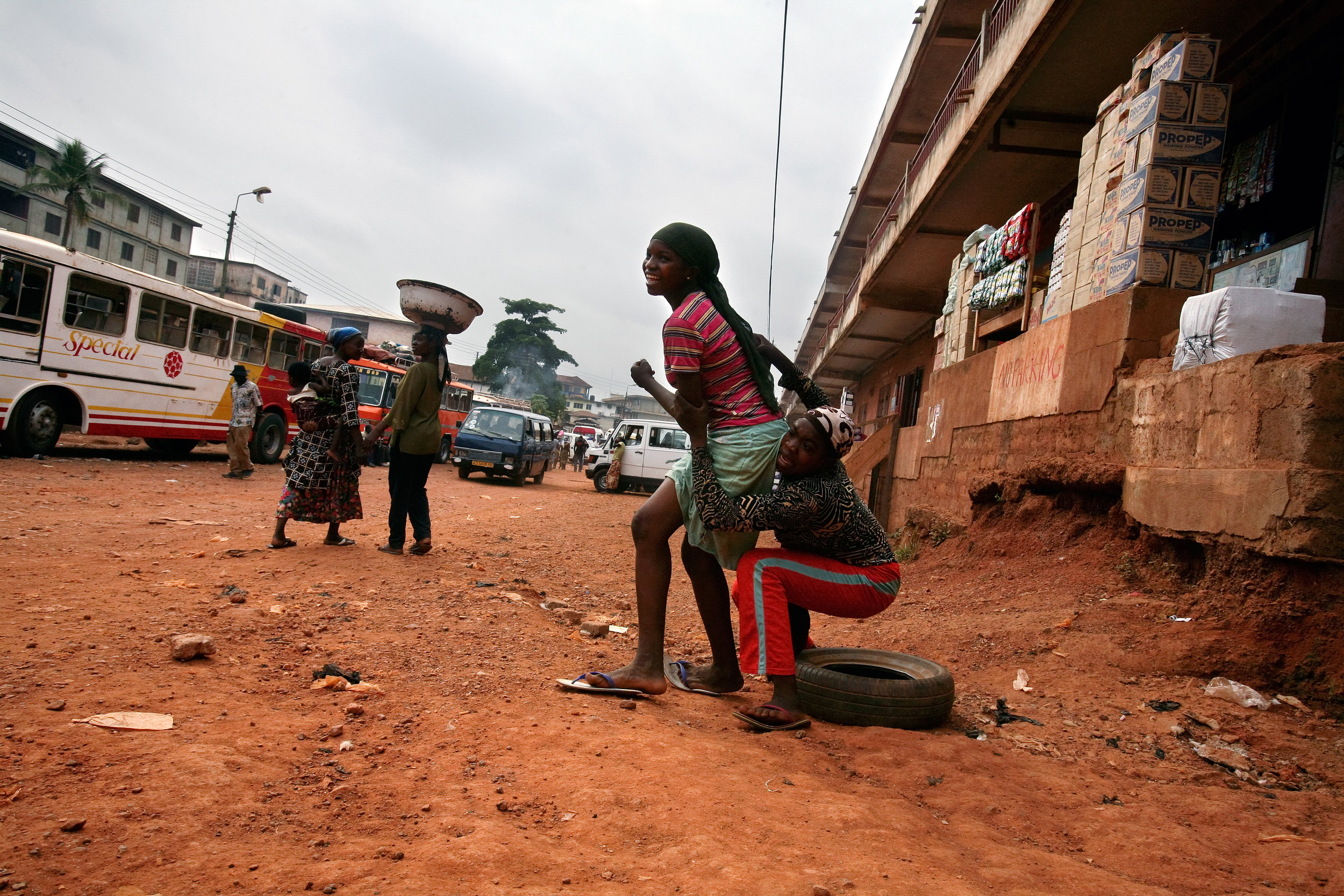  Teenage Kayayo girls rush to their feet to chase after a bus entering Doctor Mensah Market in Kumasi, Ghana, Feb. 26, 2009. 